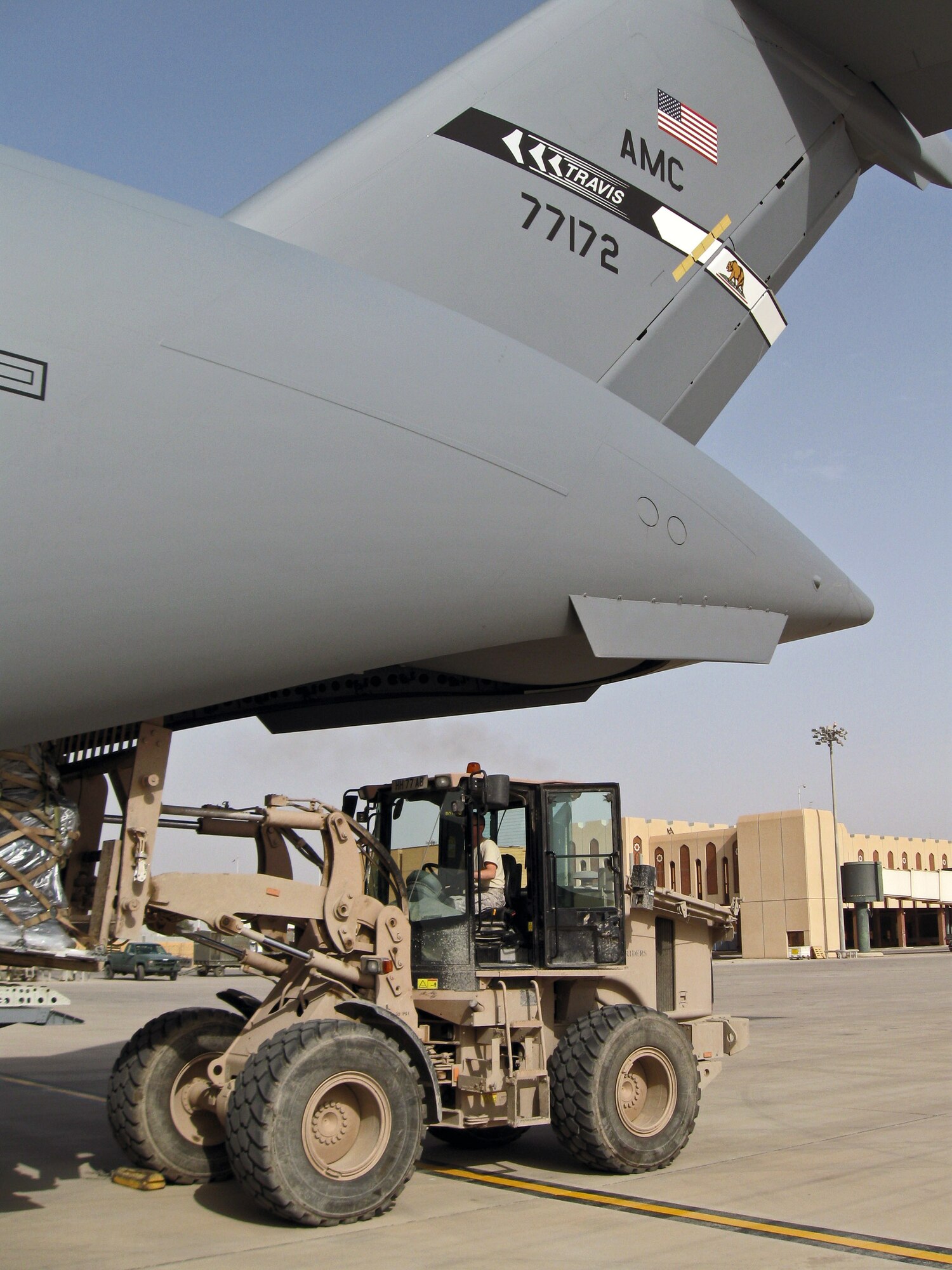 Airman 1st Class Daniel Cuhen, an aerial port specialist with the 615th Contingency Response Wing from Travis Air Force Base, Calif., unloads cargo March 31 from a C-17 Globemaster III at Basra International Airport, Iraq.  Airman Cuhen is deployed to Basra as part of a contingency response element that is supporting the transition of responsibility from British to U.S. forces  (U.S. Air Force photo/Lt. Col. John Howard)