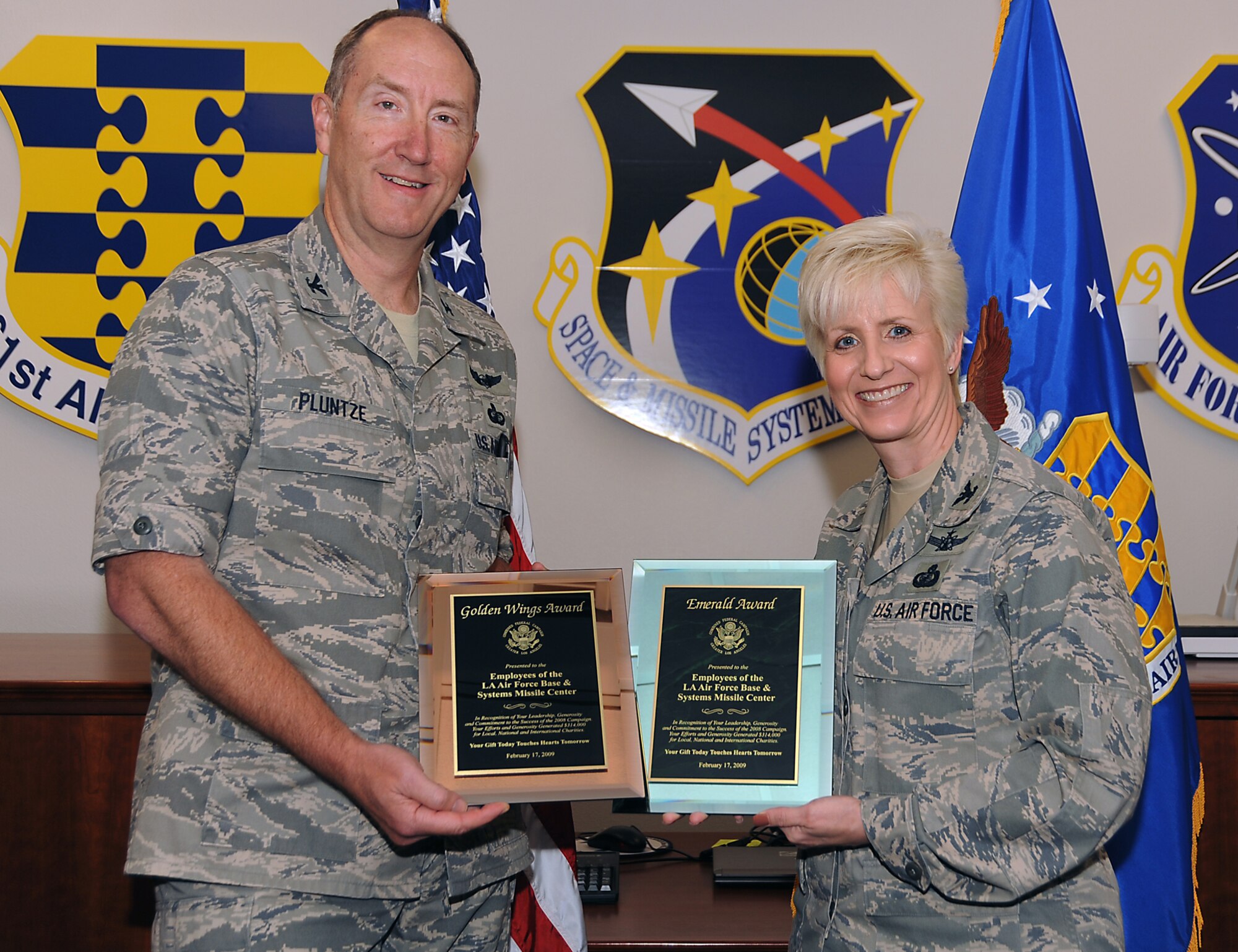 Col. Stephen Pluntze, Defense Meteorological Satellite Systems Group commander, presents to  Col. Anita Latin, 61st Air Base Wing commander, the Combined Federal Campaign’s Golden Wings and Emerald awards on behalf of Los Angeles Air Force Base. Personnel here contributed more than $300,000 to local, national and international charities during last year's CFC campaign. (Photo by Joe Juarez)