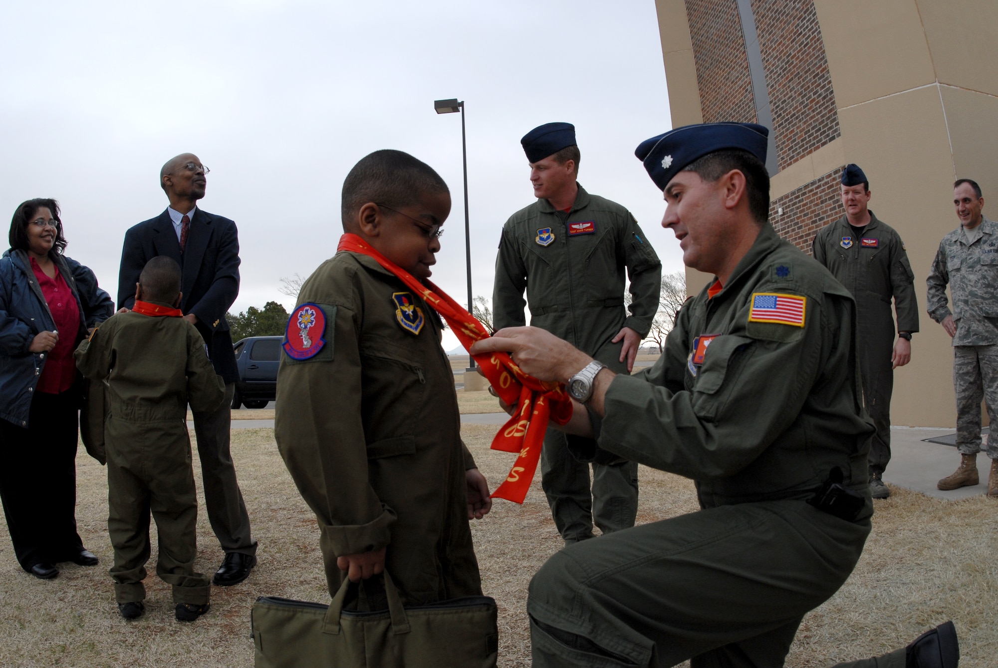 ALTUS AIR FORCE BASE, Okla. -- Lt. Col. Anthony Valerio, 97th Operations Support Squadron, gives a scarf to Zachary and Xavier Willis during the "Pilot for a Day" event. (U.S. Air Force photo/Senior Airman Jennifer L. Flores)
