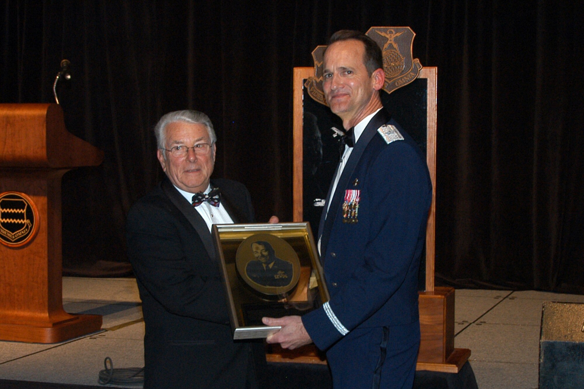 OFFUTT AIR FORCE BASE, Neb. -- Brig. Gen. James Jones, 55th Wing commander, presents the Hall of Fame Award to retired Col. William Ernst during the 55th Wing Birthday Ball at the Qwest Center March 28. The honor was bestowed upon Colonel Ernst for continued excellence and support of the 55th Wing. A plaque honoring the colonel will be displayed as part of the wing's Hall of Fame wall in the headquarters building.

 Air Force Photo by Jeff Gates                                      