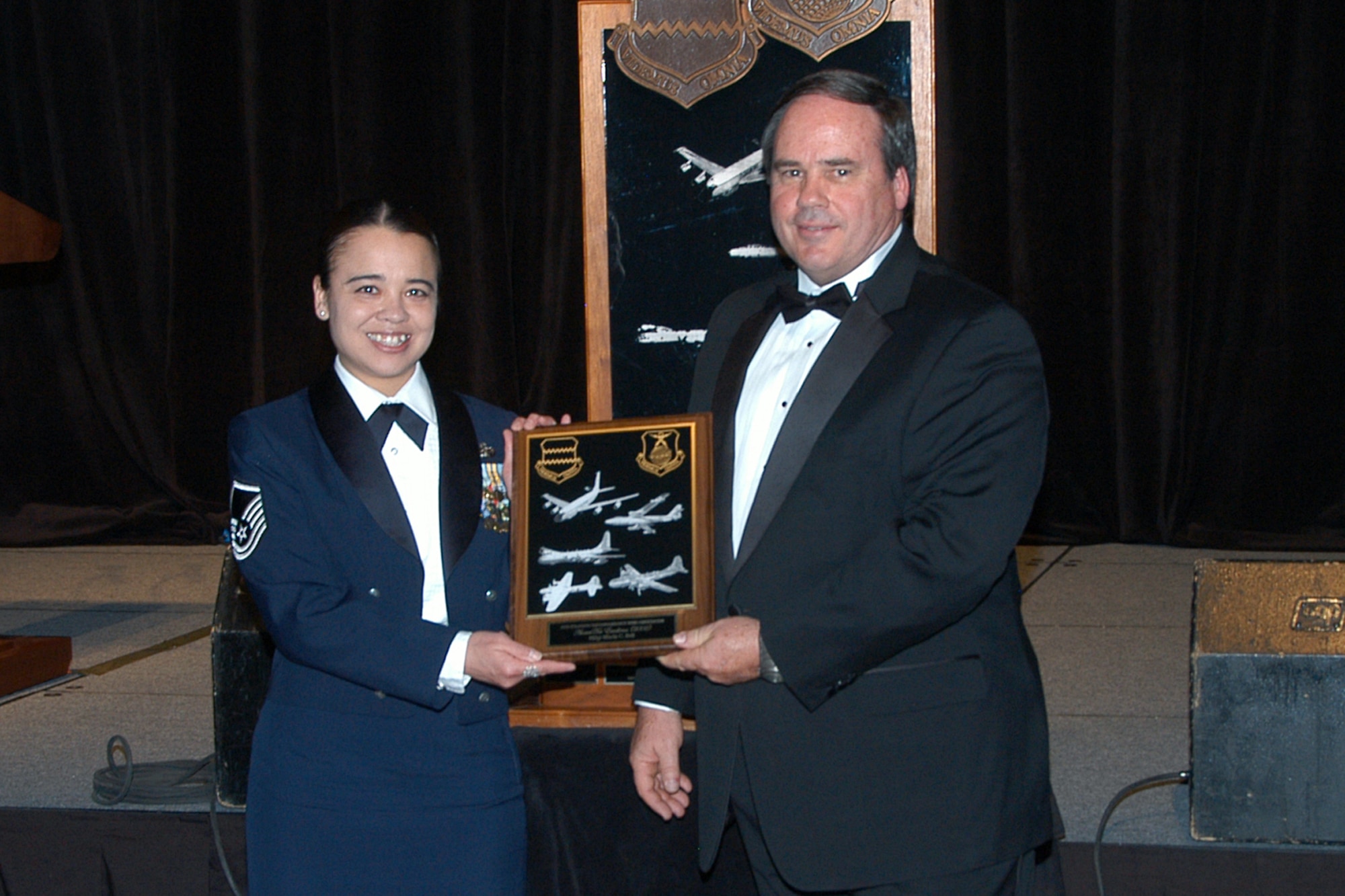OFFUTT AIR FORCE BASE, Neb. -- Master Sgt. Maria Bell, 55th Security Forces Squadron is awarded the 55th Strategic Reconnaissance Wing Association Award of Excellence by retired Lt. Col. RJ McMahon, the first recipient of the award, during the 55th Wing Birthday Ball at the Qwest Center March 28. The Award of Excellence is annually presented to an individual, group or organization in the wing that exemplifies the basic tenents of the 55th SRW which are to foster and advance the ideals of patriotism and love of country.

 Air Force Photo by Jeff Gates                                      