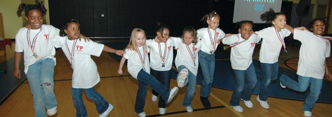 Andrews Youth Center cheerleaders perform a dance routine before an audience of family members and friends during a Sports Banquet held at the Youth Center March 27.  During the banquet, Andrews youth basketball league team members, coaches and cheerleaders received awards. The event culminated with a movie and pizza. (U.S. Air Force photo/ Bobby Jones)