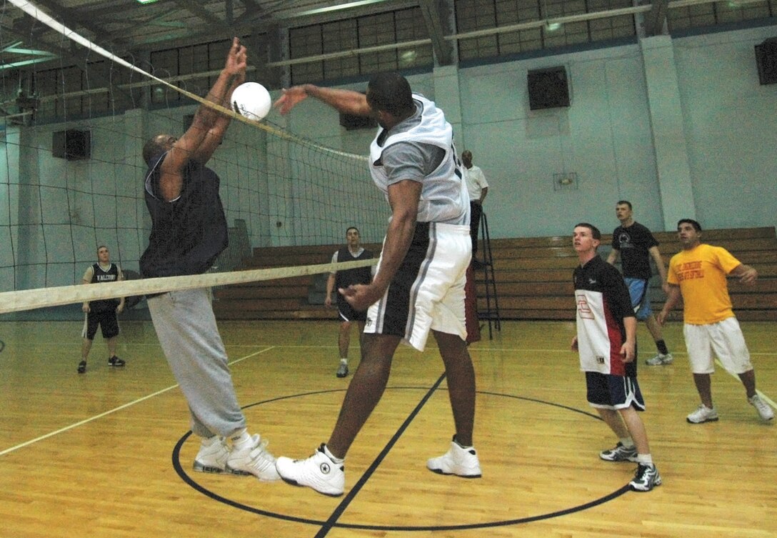 Edroy Robinson, right, 316th Civil Engineer Squadron team member, slams home a point against Robert Bowie, 113th Air Nation Guard member, during a volleyball game held at the East Fitness Center Monday.  The 316 CES won all four games straight, bringing its season record to 4 and 0. (U.S. Air Force photo/Bobby Jones)