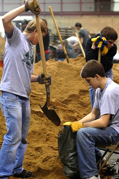 MINOT, N.D. – Members from the Bishop Ryan High School varsity baseball team help fill sand bags in the All Season’s Arena here April 1.  Volunteers from the Minot area community and Minot Air Force Base reached the goal of filling 25,000 sandbags in the first two days alone. They will continue to help in this flood relief effort until 6 p.m. April 4. (U.S. Air Force photo by Senior Airman Kelly Timney)
