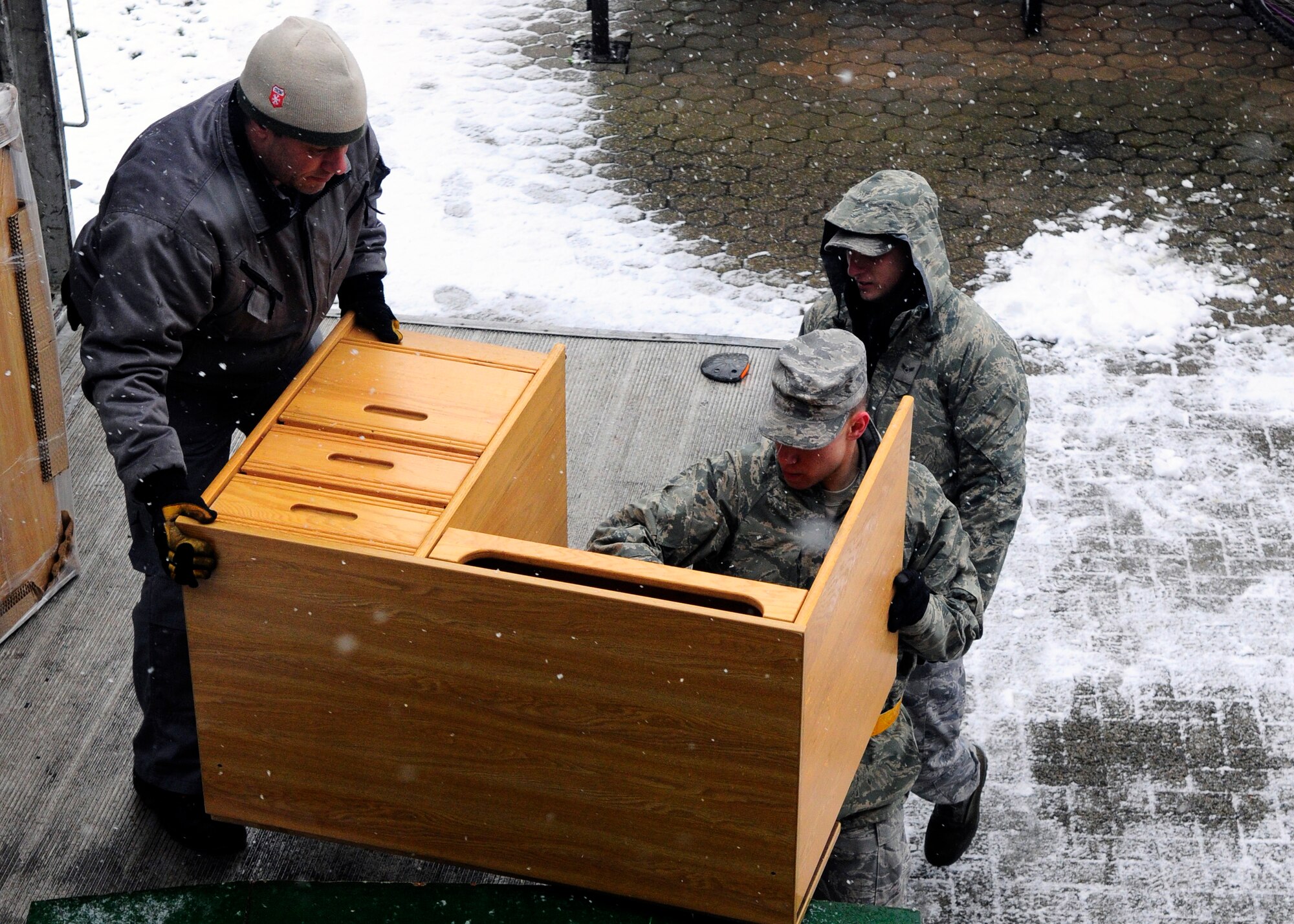 SPANGDAHLEM AIR BASE, Germany – Airman 1st Class Brent Dyson and Airman 1st Class Michael Debois, both from the 52nd Equipment Maintenance Squadron, assist Frank Diedenhoven, Traffic Management Office contractor, to replace furniture in Sanchez Hall March 25, 2009. Furniture removed from the dormitory was donated to a German orphanage. (U.S. Air Force photo by Airman 1st Class Staci Miller)