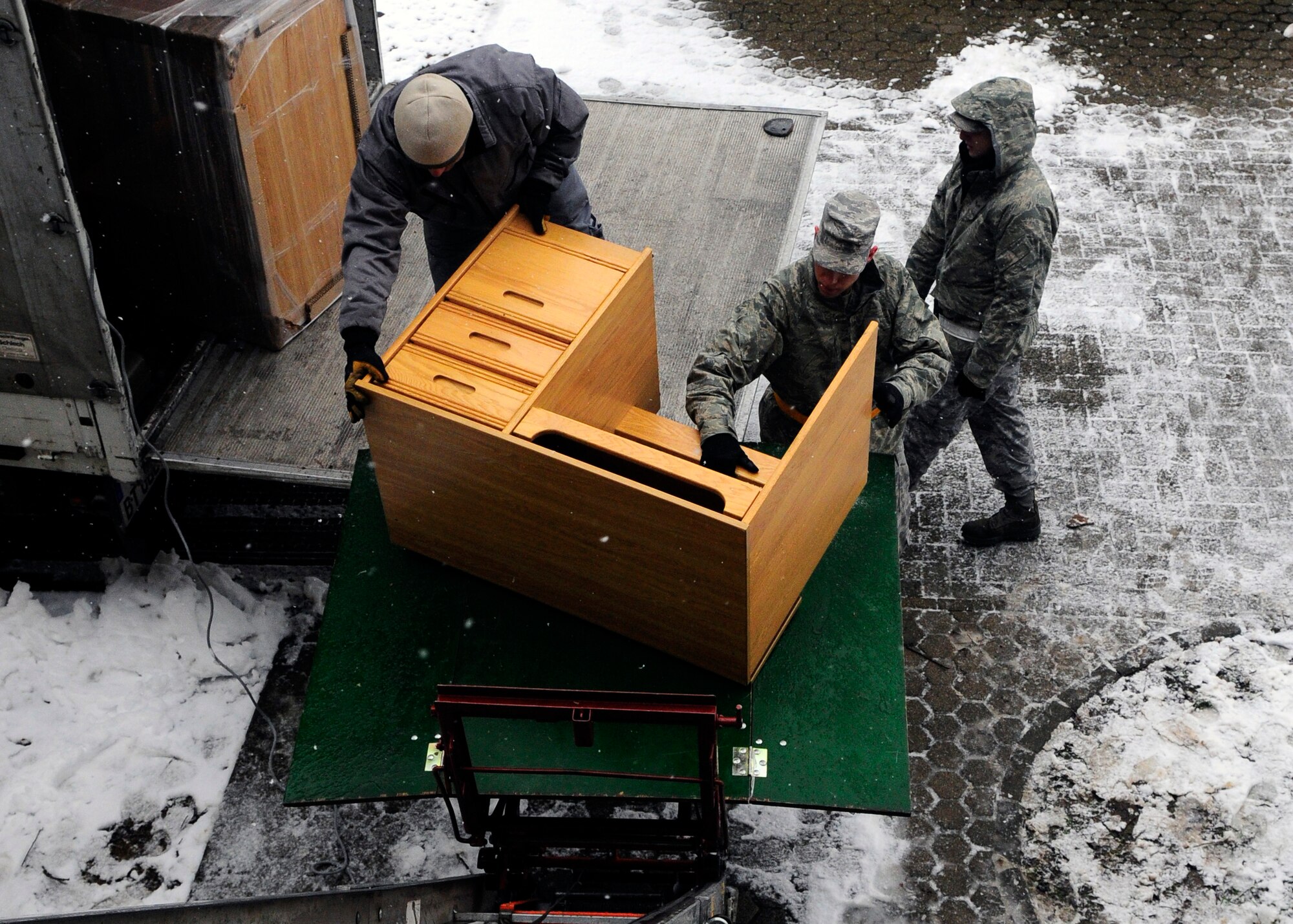 SPANGDAHLEM AIR BASE, Germany – Airman 1st Class Brent Dyson and Airman 1st Class Michael Debois, both from the 52nd Equipment Maintenance Squadron, assist Frank Diedenhoven, Traffic Management Office contractor, to replace furniture in Sanchez Hall March 25, 2009. Furniture removed from the dormitory was donated to a German orphanage. (U.S. Air Force photo by Airman 1st Class Staci Miller)