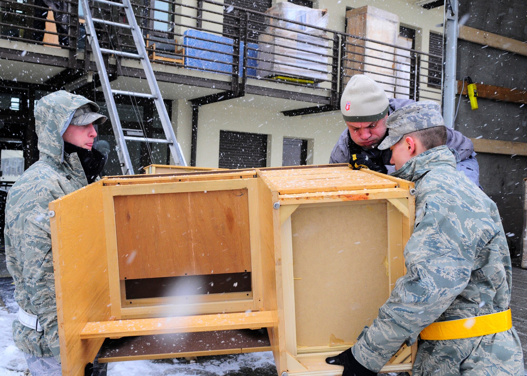 SPANGDAHLEM AIR BASE, Germany – Airman 1st Class Brent Dyson and Airman 1st Class Michael Debois, both from the 52nd Equipment Maintenance Squadron, assist Frank Diedenhoven, Traffic Management Office contractor, to replace furniture in Sanchez Hall March 25, 2009. Furniture removed from the dormitory was donated to a German orphanage. (U.S. Air Force photo by Airman 1st Class Staci Miller)