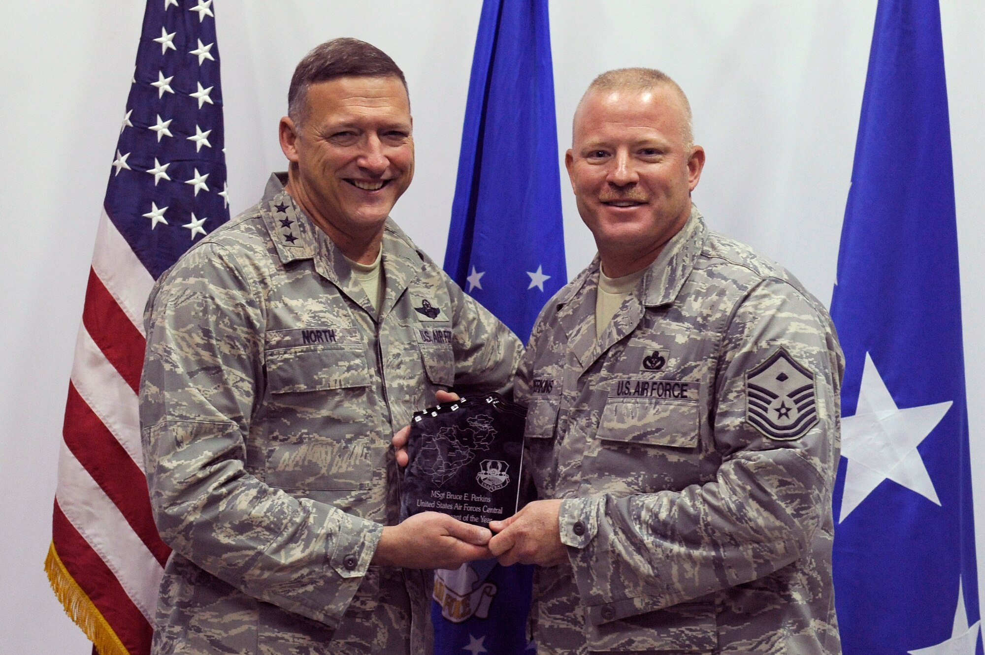 SOUTHWEST ASIA - Lt. Gen. Gary North, U.S. Air Forces Central, commander presents Master Sgt. Bruce E. Perkins with the AFCENT First Sergeant of the year award, April 1. Sergeant Perkins hails from Odin, Ill. (U.S. Air Force photo by Senior Airman Brian J. Ellis) (Released)