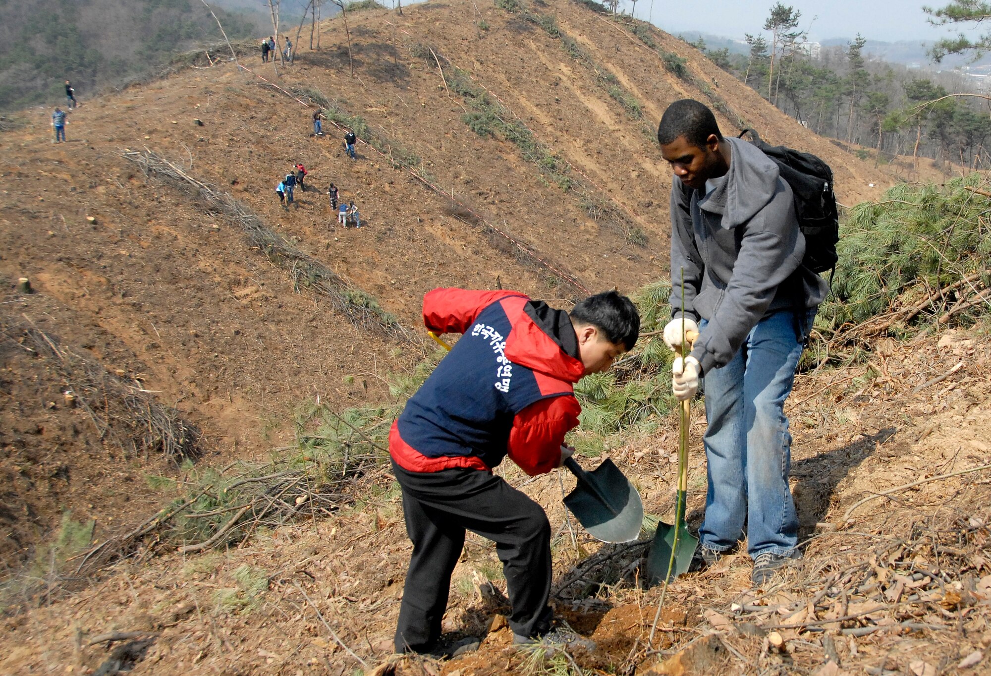 Members from Osan Air Base joined local Songtan community members April 2 to plant trees in Jisan-dong, Songtan, to celebrate Arbor Day. The event brought nearly 200 Koreans and Americans together to plant trees along the mountainside. (U.S. Air Force Photo/Pak, Yong Hui)