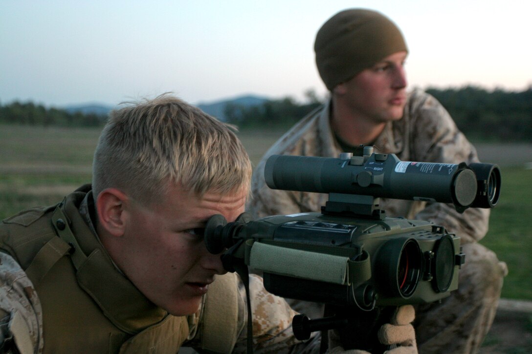 U.S. Marine Corps Cpl. Jarrod Romine, left, a forward observer, peers through an AN/PAS-22, a hand-held thermal imaging sight, while selecting targets prior to taking part in a live fire exercise as Pfc. Leif Anderson looks on, Fort Hunter Ligget, Calif., March 29, 2009.  The sight and the infrared zoom laser illuminator designator, with the long-range infrared pointer affixed to the top of it, provide an integrated targeting system with which can mark targets for close air support missions. The Marines are assigned to the 11th Marine Expeditionary Unit’s fire control team. 