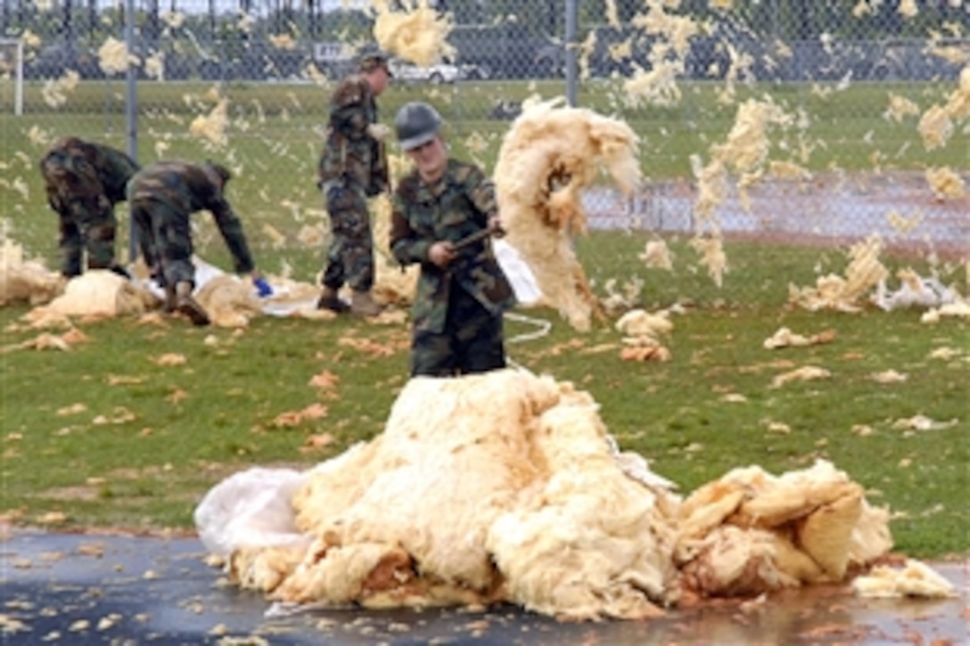 U.S. Navy Seabees remove debris after strong winds struck the base gym in Gulfport, Miss., April 2, 2009. The Seabees are assigned to the Naval Construction Battalion Center.