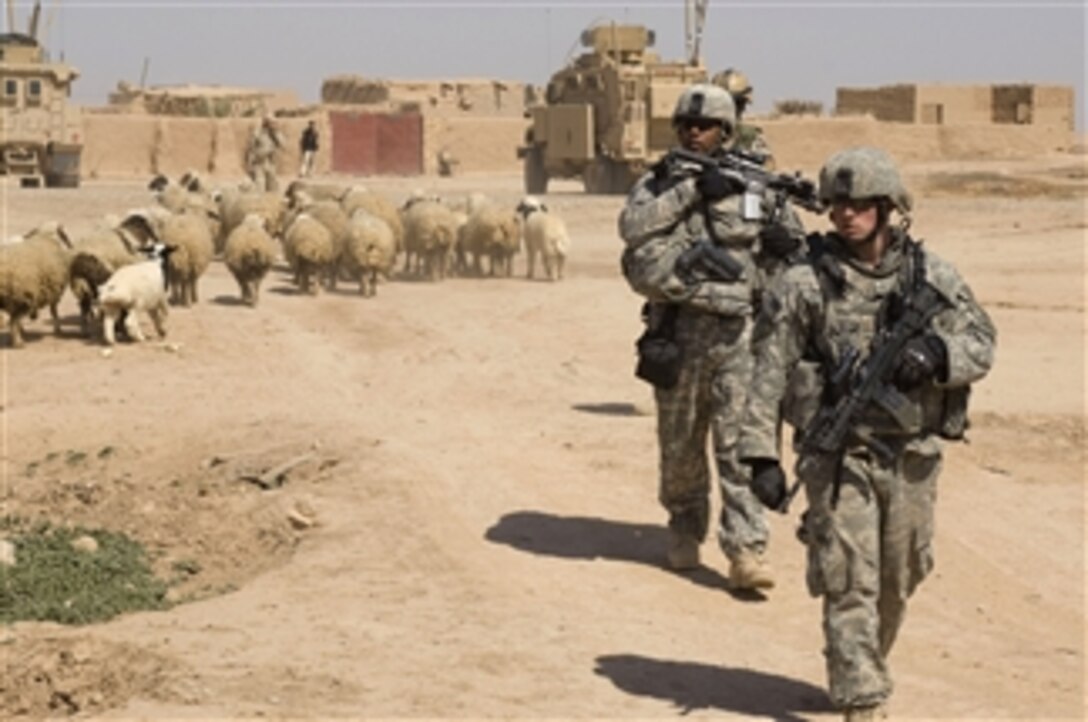 U.S. Army soldiers from Green Platoon, 1st Battalion, 24th Infantry Regiment, 1st Stryker Brigade Combat Team, 25th Infantry Division provide security while soldiers from 2nd Battalion, 19th Brigade, 5th Iraqi Division provide humanitarian aid to villagers in Shuzayf, Iraq, on March 27, 2009.  