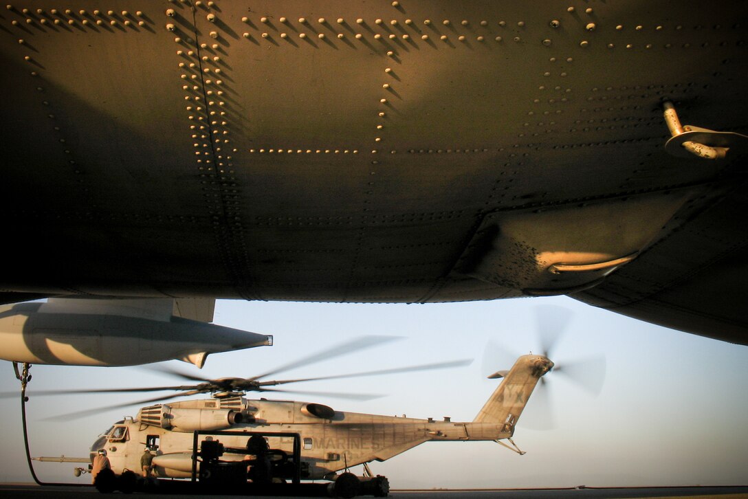 A CH-53 Super Stallion takes on fuel from a KC-130J refueler aircraft at Castle Airport April 3. Twelve helicopters from the 11th Marine Expeditionary Unit, eight transporting infantrymen, stopped here on a route to a simulated raid site during the MEU's recent air-ground task force exercise held at several California installations.