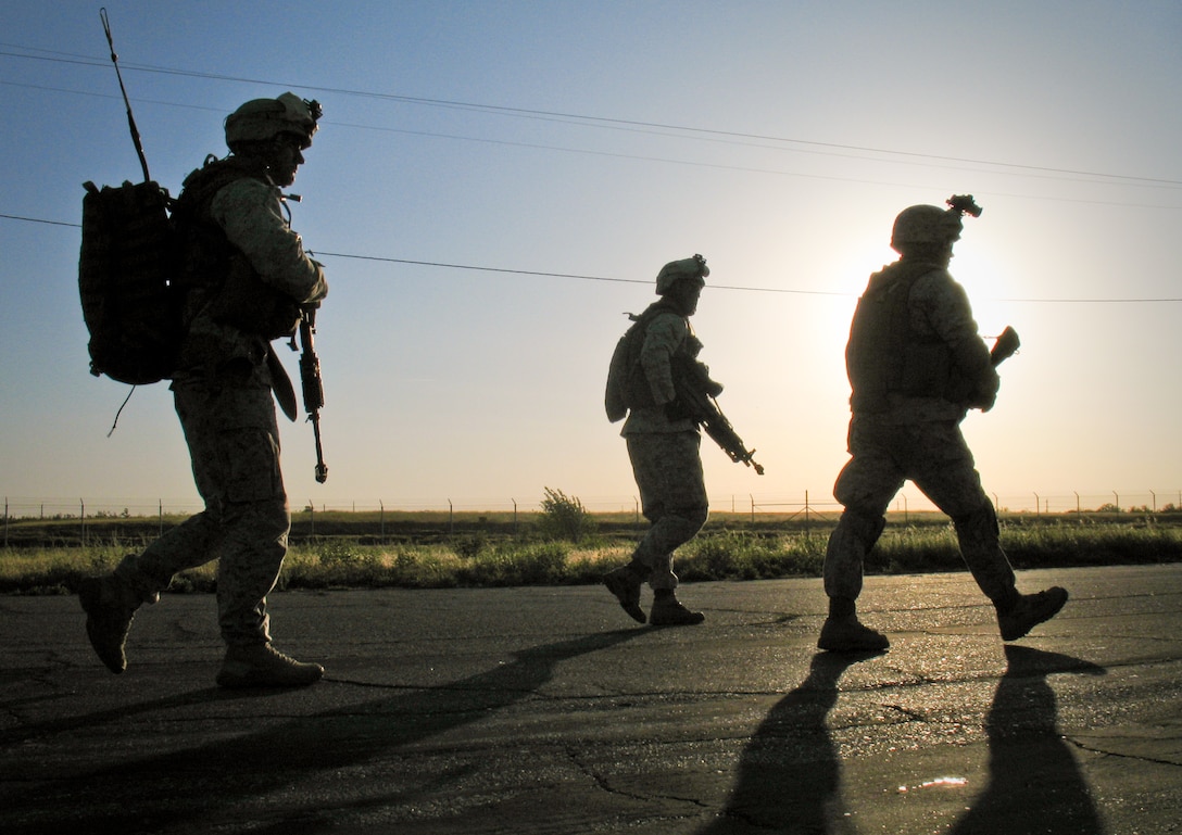 Company E Marines disembark to a waiting point April 3 at Castle Airport as the helicopter that brought them here lines up for fuel from a KC-130 refueler. Twelve helicopters, eight transporting infantrymen, stopped here during the 11th Marine Expeditionary Unit's recent air-ground task force exercise. The infantrymen, who were en route to a simulated raid, serve with the MEU's ground-combat element, 2nd Battalion, 4th Marines, aka the Magnificent Bastards.