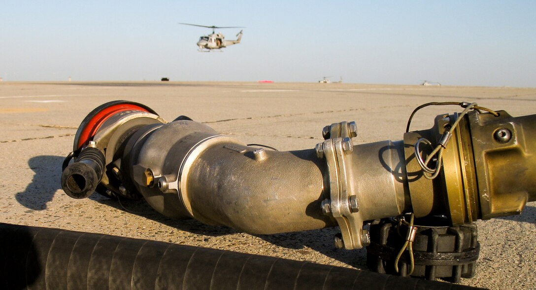 A fuel nozzle attached to a KC-130J refueler aircraft lies on the Castle Airport tarmac as helicopters come in for a fill-up April 3. The aircraft, assets of the 11th Marine Expeditionary Unit, were transporting infantrymen to a simulated raid site during the MEU's recent air-ground task force exercise held at several California installations.