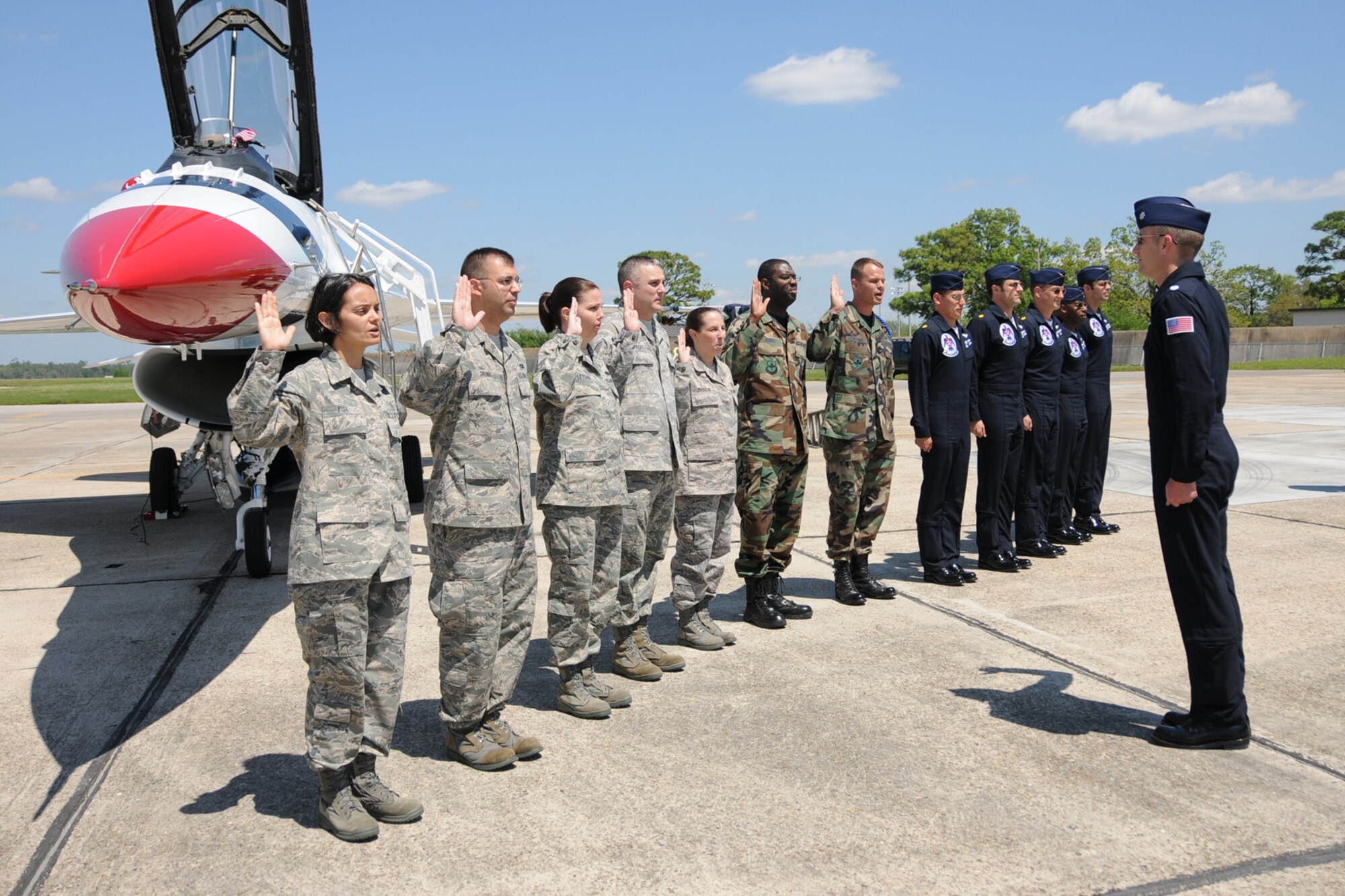 Seven Keesler Airmen reenlisted alongside one of the F-16 Thunderbirds April 3 in advance of the the Thunder on the Bay Air Show April 4-5.  The Thunderbirds are making their first air show appearance at Keesler since 1994.  It’s Keesler’s first air show in five years.  (U.S. Air force photo by Kemberly Groue)