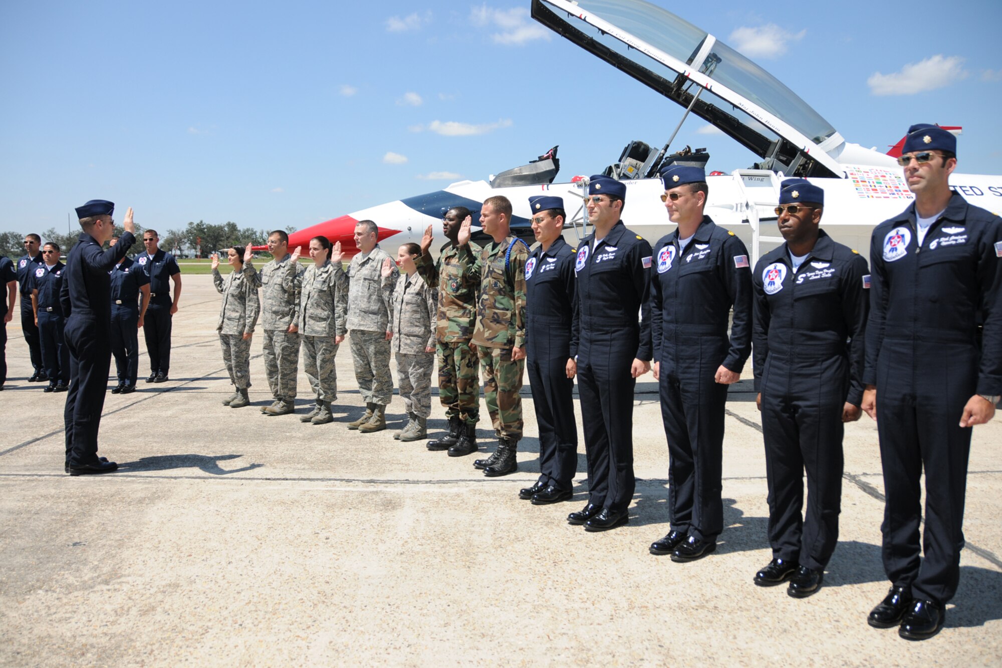 Seven Keesler Airmen reenlisted alongside one of the F-16 Thunderbirds March 3 in advance of the the Thunder on the Bay Air Show March 4-5.  The Thunderbirds are making their first air show appearance at Keesler since 1995.  It’s Keesler’s first air show in five years.  (U.S. Air force photo by Kemberly Groue)