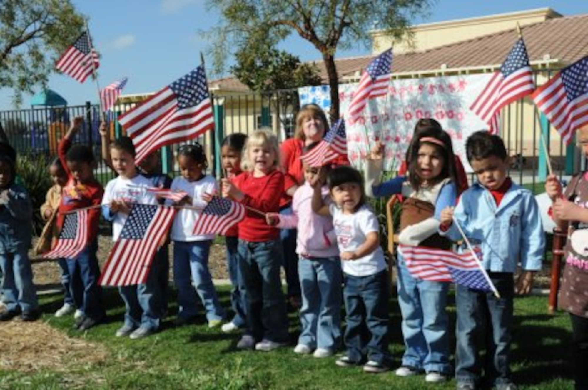 Children from Peterson Child Development Center wave flags to celebrate “Red, White and Blue day.” (Courtesy photos)