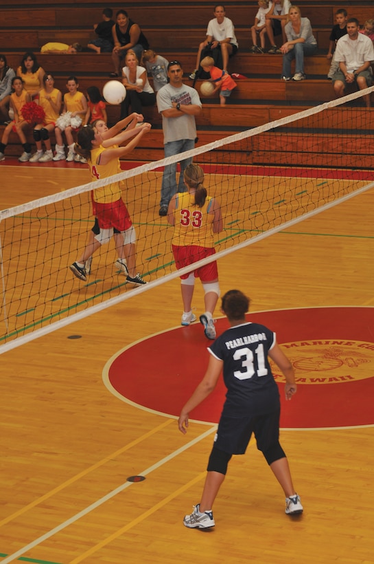During the opening weekend of the 2009 Hawaii Military Youth Athletic Association volleyball competitive season, Kaneohe Bay players lunge for the ball during a game against the Pearl Harbor team at the Semper Fit Center gymnasium Saturday.::r::::n::