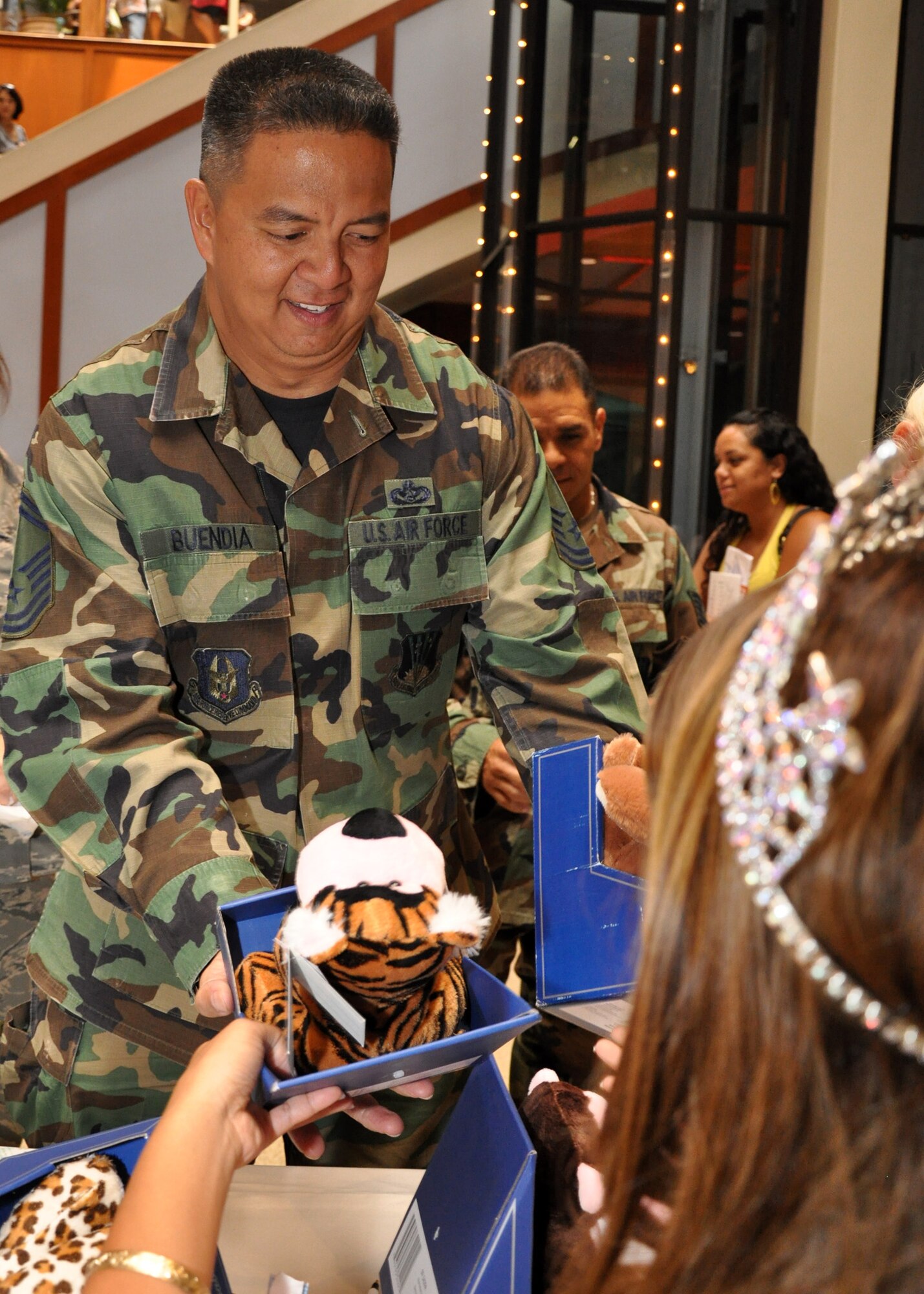 Senior Master Sgt. John Buendia, 624th Civil Engineer Squadron, hands in stuffed animals donated by the 624th Regional Support Group for the 12th Annual Teddy Bear Round-up and Family Resource Fair April 4 at Pearlridge Shopping Center, Aiea, Hawaii. The drive was in support of April Child Abuse Prevention Month. The 42 bears brought by the Air Force Reservists were added to a growing pile in the center of the mall that are destined to go to local children and families who are in crisis and in need of special attention. (Air Force photo/Master Sgt. Daniel Nathaniel) 