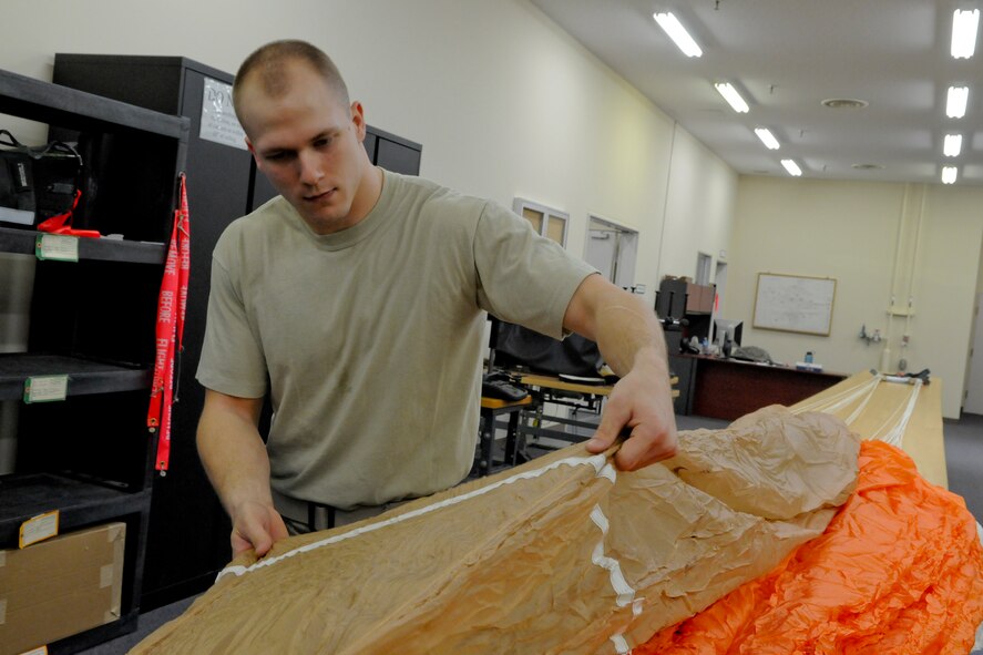 MISAWA AIR BASE, Japan -- Airman 1st Class Carl Covington, 35th Operations Support Squadron air crew flight equipment journeyman, inspects a canopy March 31, 2009. During the inspection, Airman Covington checked for moisture, acid stains, blood stains, missing stitches and holes. (U.S. Air Force photo by Senior Airman Jamal D. Sutter)