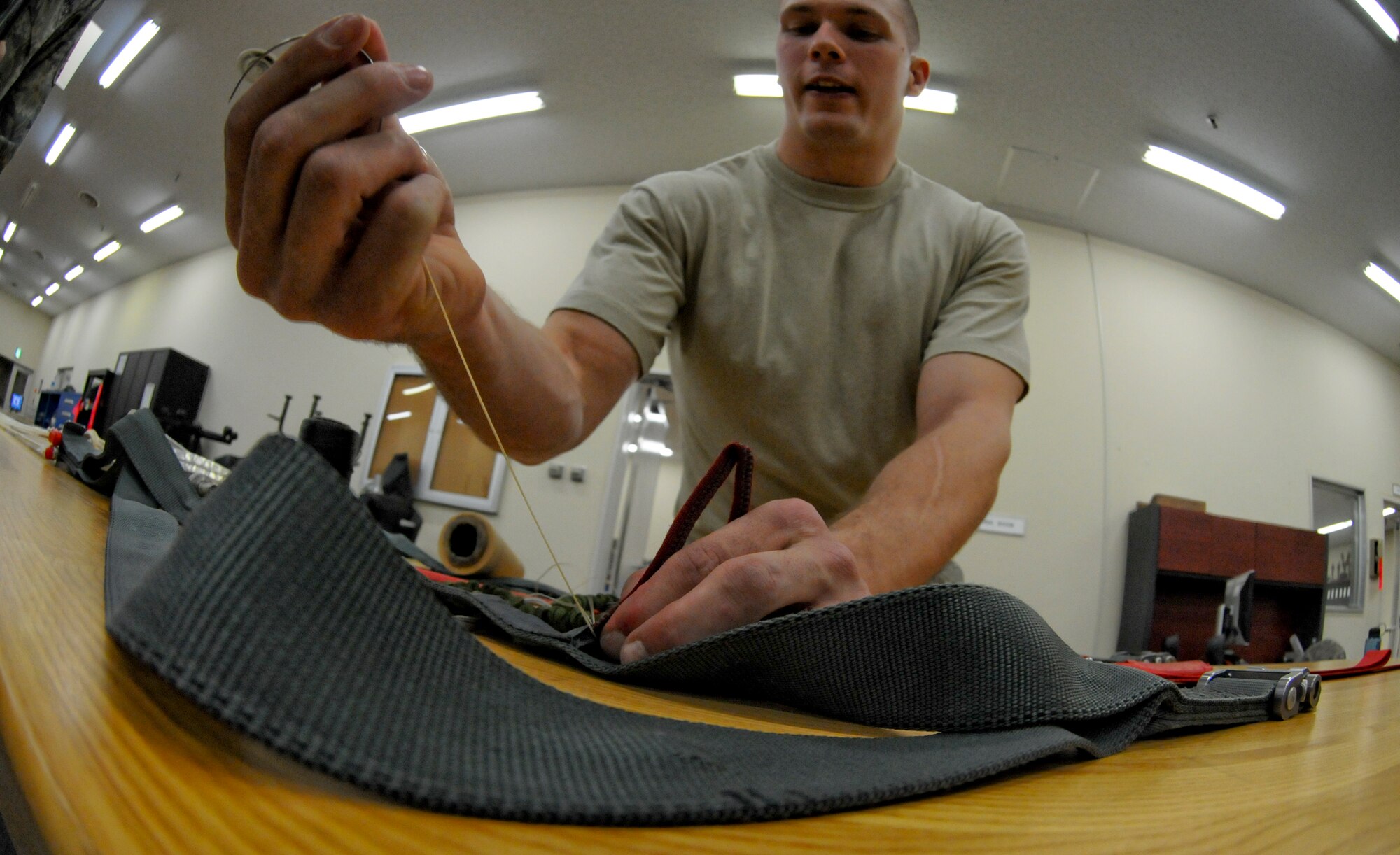 MISAWA AIR BASE, Japan -- Airman 1st Class Carl Covington, 35th Operations Support Squadron air crew flight equipment journeyman, replaces tackings on a parachute riser March 31, 2009. Each parachute is inspected once a year; inspections can take anywhere from four hours to a full duty day to complete. (U.S. Air Force photo by Senior Airman Jamal D. Sutter)
