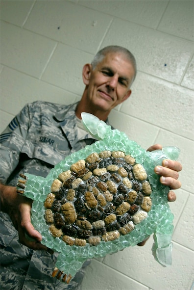 Chief Master Sgt. Dan Cogar, 44th Aerial Port Squadron, presents a turtle he created from glass he collected on the beach. (Air Force photo/Staff. Sgt. Jennie Chamberlin)
