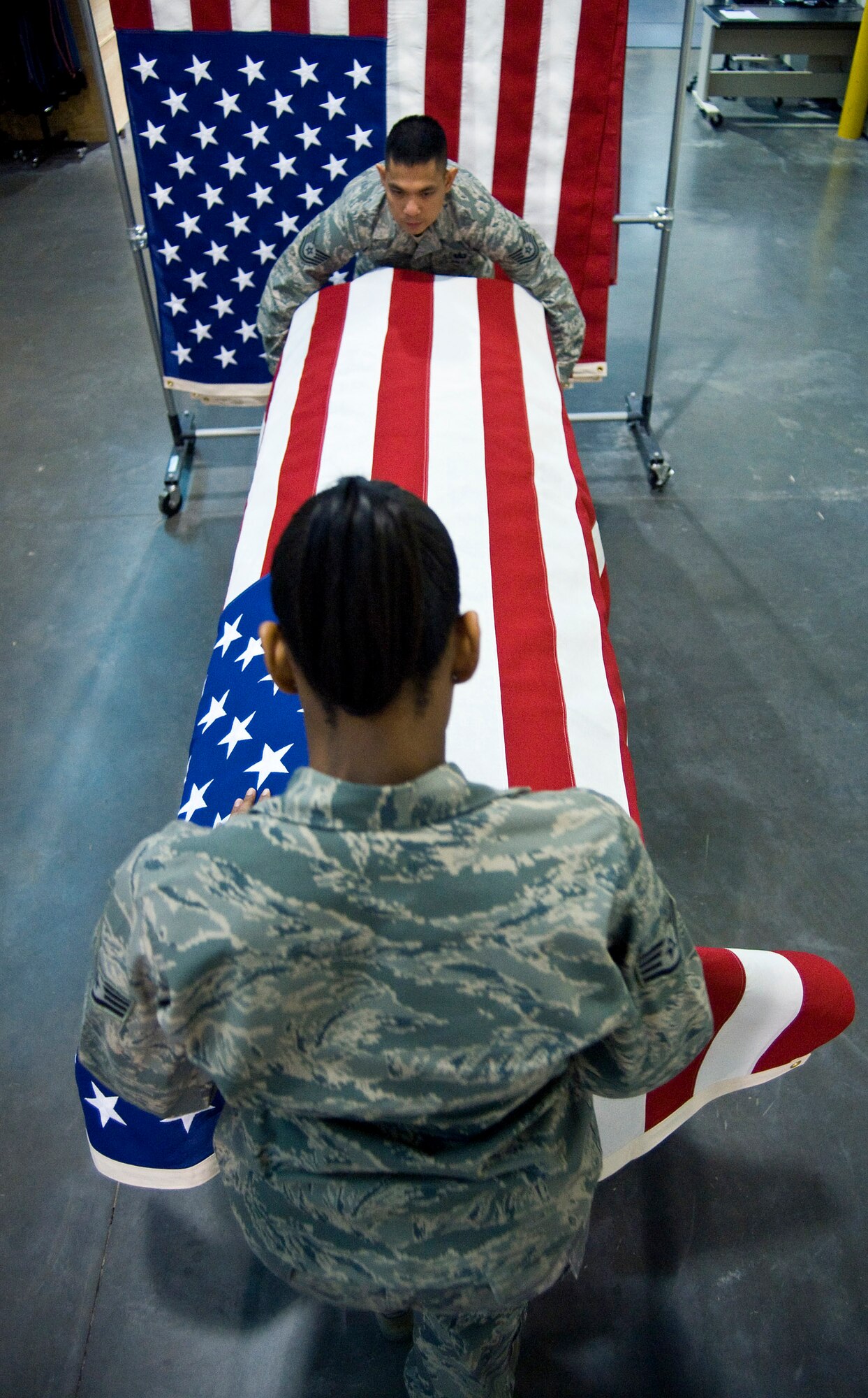 Shipping Specialists Staff Sgt. Star Samuels (front) and Tech. Sgt. Willard Rico place a U.S. flag over a casket March 31 during a dry run of shipping process procedures for the dignified transfer of remains at the Charles C. Carson Center for Mortuary Affairs, Dover Air Force Base, Del.  The center is the Defense Department's largest joint-service mortuary facility and the only one in the continental United States. Sergeant Samuels is deployed from the 43rd Force Support Squadron at Pope AFB, N.C.  Sergeant Rico is deployed from the 60th FSS, Travis AFB, Calif.  (U.S. Air Force photo/Staff Sgt. Bennie J. Davis III)