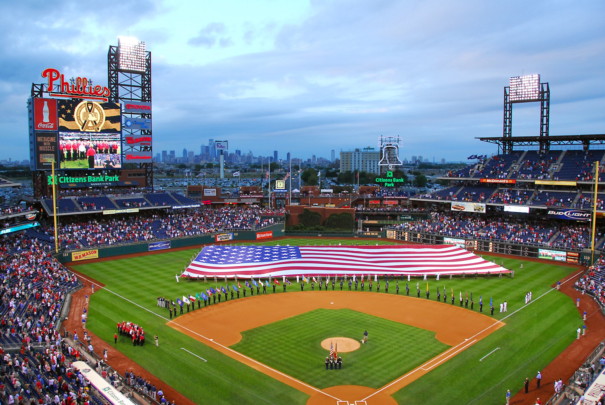 Servicemen and women from the 111th Fighter Wing, Pa. Army National Guard, as well as active duty Navy and Marine Corp members unfurled a 120-by-250 foot American Flag across the outfield of Citizens Bank Park during a Patriots Day ceremony Sept. 11 before the game. While the center field size flag was being opened, volunteer firefighters from Philadelphia, Delaware County and Warminster fire companies marched around the bases each carrying a state flag.