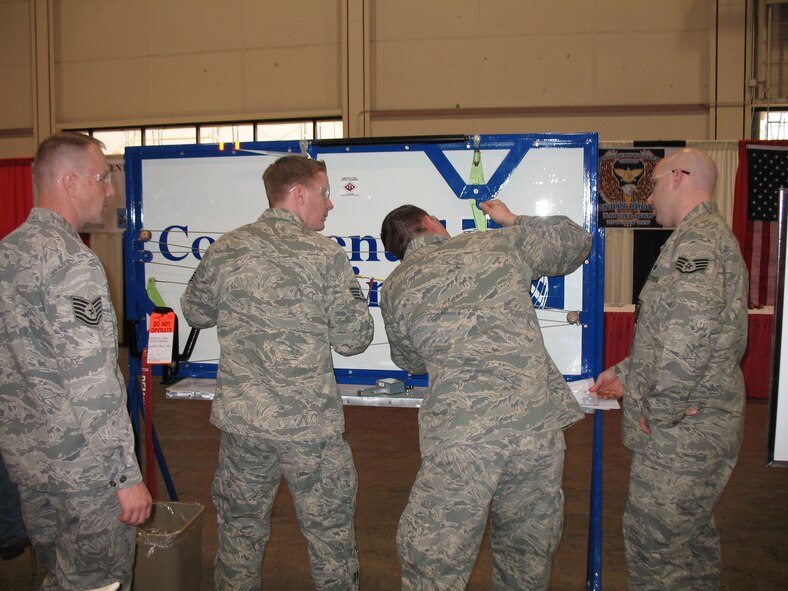 McChord maintenance team members simulate rigging a flight control using a tensiometer to measure tension while adjusting two turnbuckles to obtain correct specifications in a timed event at the AMTS maintenance skills competition. (Courtesy photo)