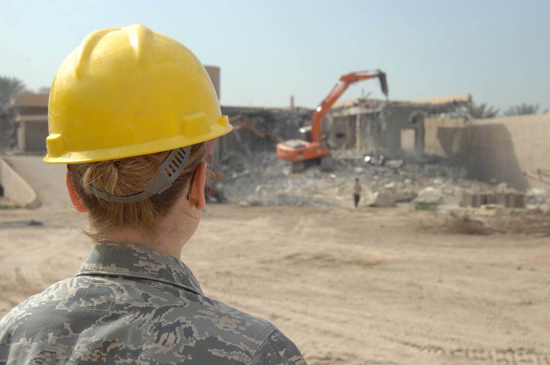Capt. Michelle Sterling looks on while one of the three villas, once belonging to bath party members is demolished once belonging to Ba'ath party members is being demolished in March in Iraq. The villas are now being demolished to make room for a new foreign embassy. Captain Sterling is the Joint Area Support Group-Central project payment officer. (U.S. Air Force photo/Staff Sgt. Tim Beckham) 

