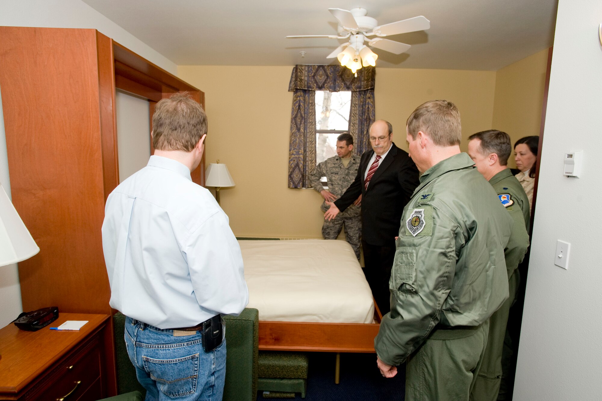 ELMENDORF AIR FORCE BASE, Alaska -- Mike Higby, North Star Inn lodging manger (center in black suit), Shows off Air Force lodging's first Murphy bed during grand opening of Denali Hall April 3, 2009. North Star Inn added another 119 suites, bringing the total number of lodging rooms available to 591 with the renovotions of Denali Hall complete. The renovations took 18 months and cost $22 million. (U.S. Air Force photo by Senior Airman Jonathan Steffen) 
