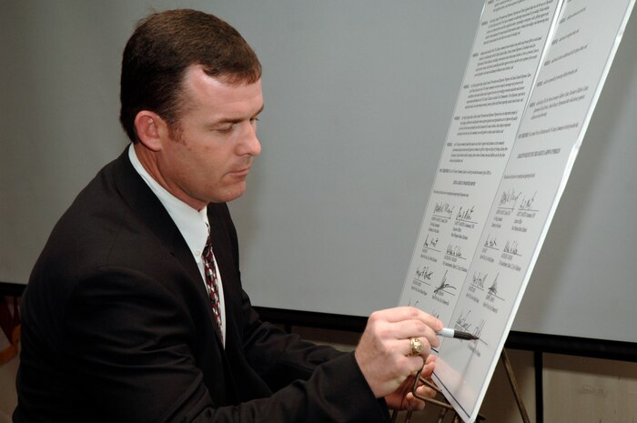 John Cribb signs a proclamation during the 2nd Annual Joint Community Proclamation Signing ceremony at the Charleston Club April 2. The signing of the proclamation continues collaboration with local communities and military installations for prevention of sexual assault and child abuse. Representatives from six nearby communities, along with the Naval Weapons Station Charleston, joined Charleston AFB in signing the proclamation.  Mr. Cribb is the city administrator representing the city of Hanahan.  (U.S. Air Force photo/Staff Sgt. Marie Cassetty)