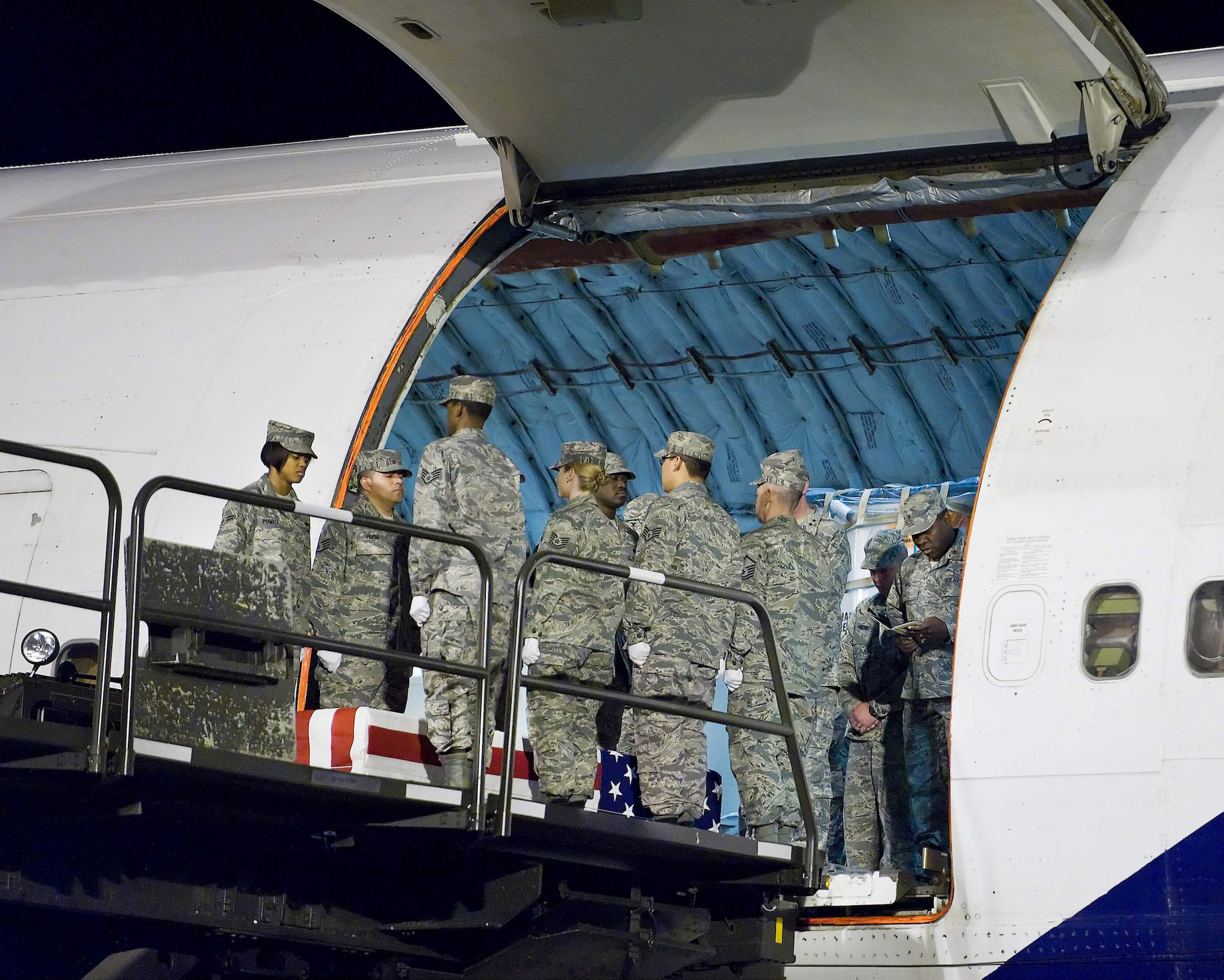 An Air Force Mortuary Affairs Operations Center carry team transfers the remains of Air Force Staff Sgt. Phillip A. Myers, of Hopewell, Va., from an aircraft at Dover Air Force Base, Del., April 5. Sergeant Myers died April 4 near Helmand Province, Afghanistan, from wounds suffered from an improvised explosive device. He was assigned to the 48th Civil Engineer Squadron, Royal Air Force Lakenheath, United Kingdom. Sergeant Myers' family is the first to allow media to cover the dignified transfer under the new Department of Defense policy. (U.S. Air Force photo/Roland Balik)