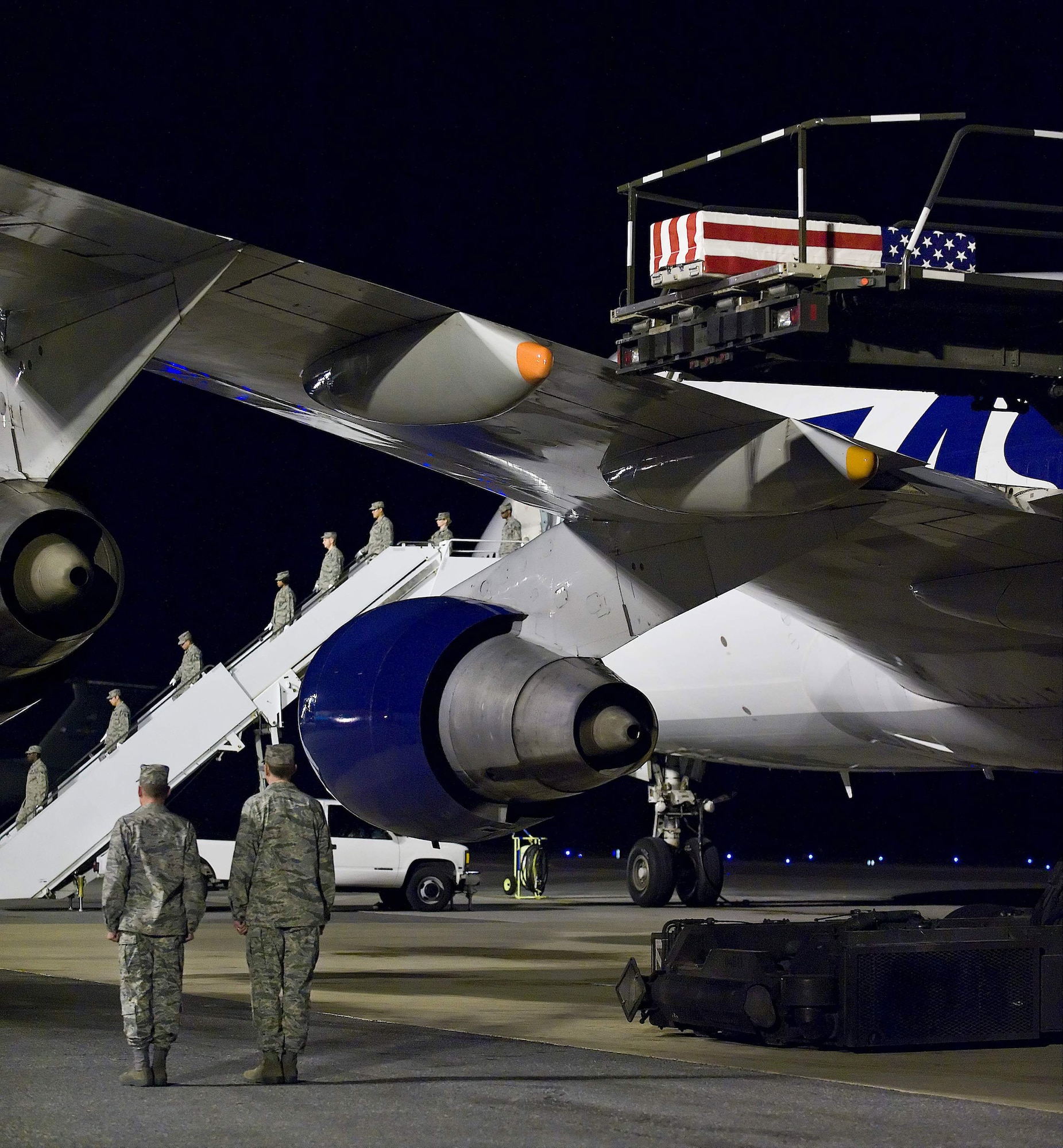 An Air Force Mortuary Affairs Operations Center carry team wait for the remains of Air Force Staff Sgt. Phillip A. Myers, of Hopewell, Va., to be lowered form the aircraft at Dover Air Force Base, Del., April 5. Sergeant Myers died April 4 near Helmand Province, Afghanistan, from wounds suffered from an improvised explosive device. He was assigned to the 48th Civil Engineer Squadron, Royal Air Force Lakenheath, United Kingdom. Sergeant Myers' family is the first to allow media to cover the dignified transfer under the new Department of Defense policy. (U.S. Air Force photo/Roland Balik)