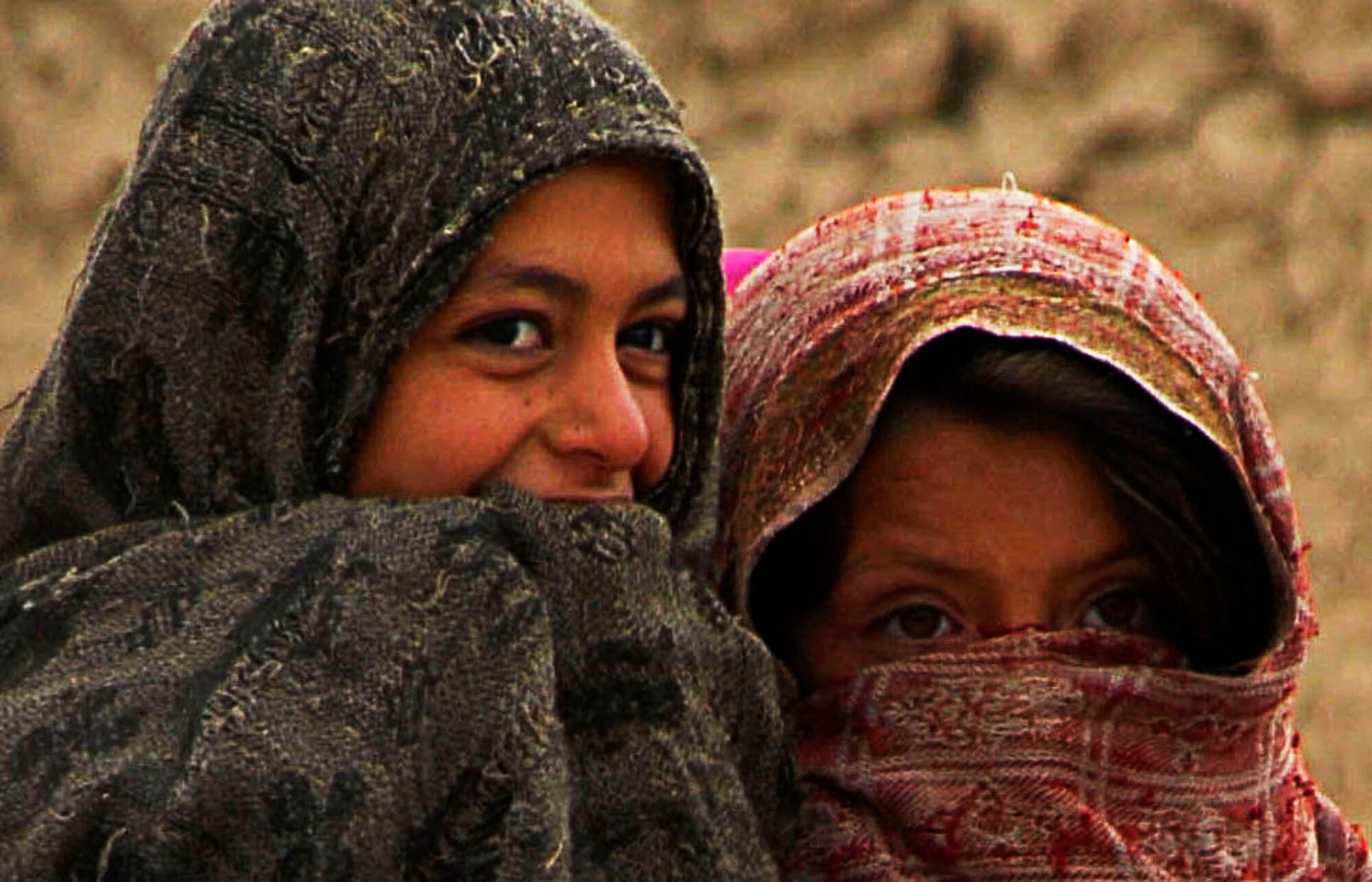 Children in a local village near Bagram Air Field, Afghanistan, giggle as
they watch Airmen hand out humanitarian goods on April 1. The items provided
included clothes, blankets, shoes and toys.  (U.S. Air Force photo/ Senior
Airman Erik Cardenas)(Released)  
