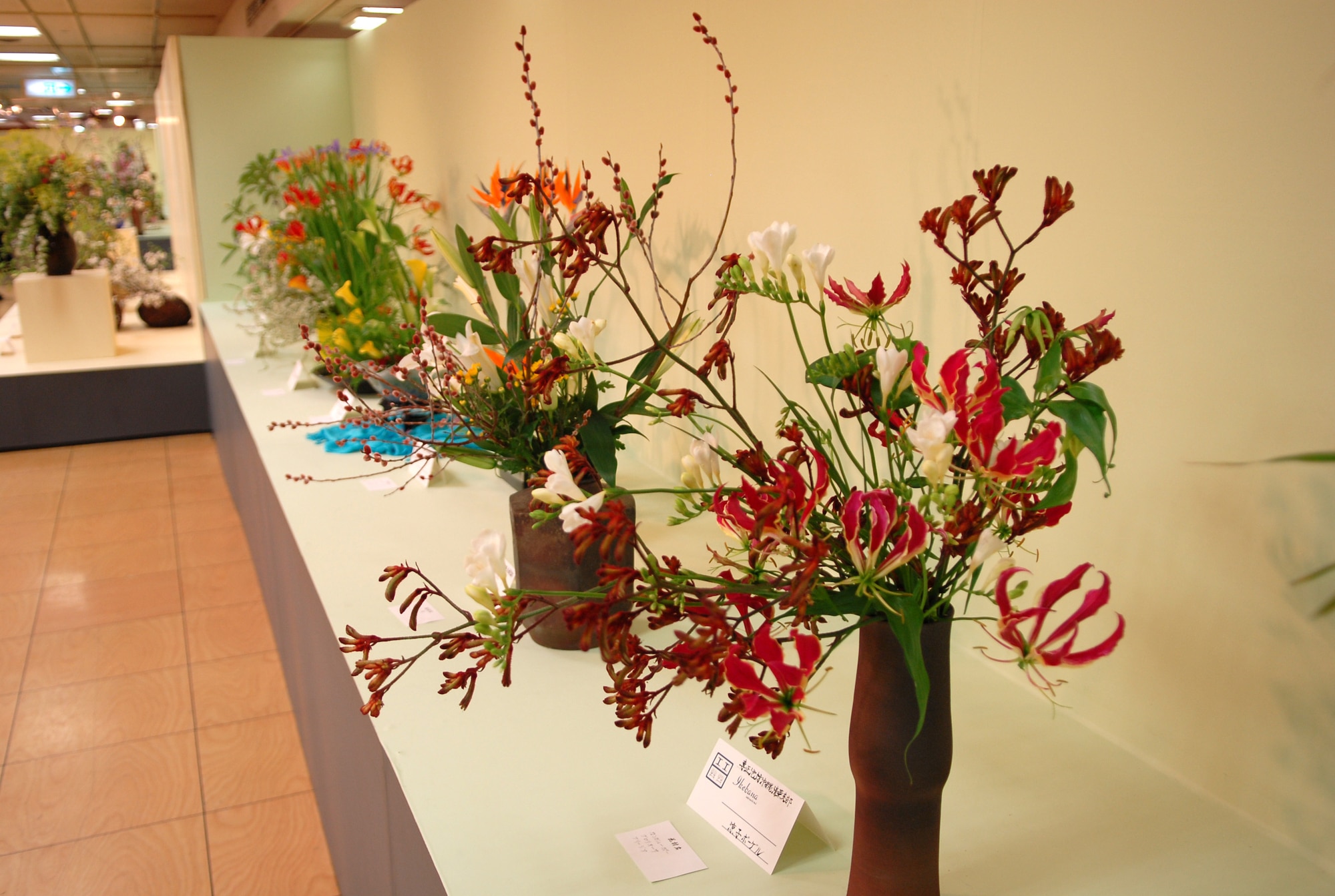 Flower arrangements from Kadena USO ikebana students are displayed at the 51st Ikebana International Okinawa Chapter Charity 10 Flower Exhibition March 27-29.  Ms. Robbins teaches many people from different bases in Okinawa.  In October, the Ikebana International Okinawa Chapter and some students from the Kadena USO will go to the White House in Washington, D.C., for a flower demonstration and lecture. (U.S Air Force photo/Junko Kinjo)  