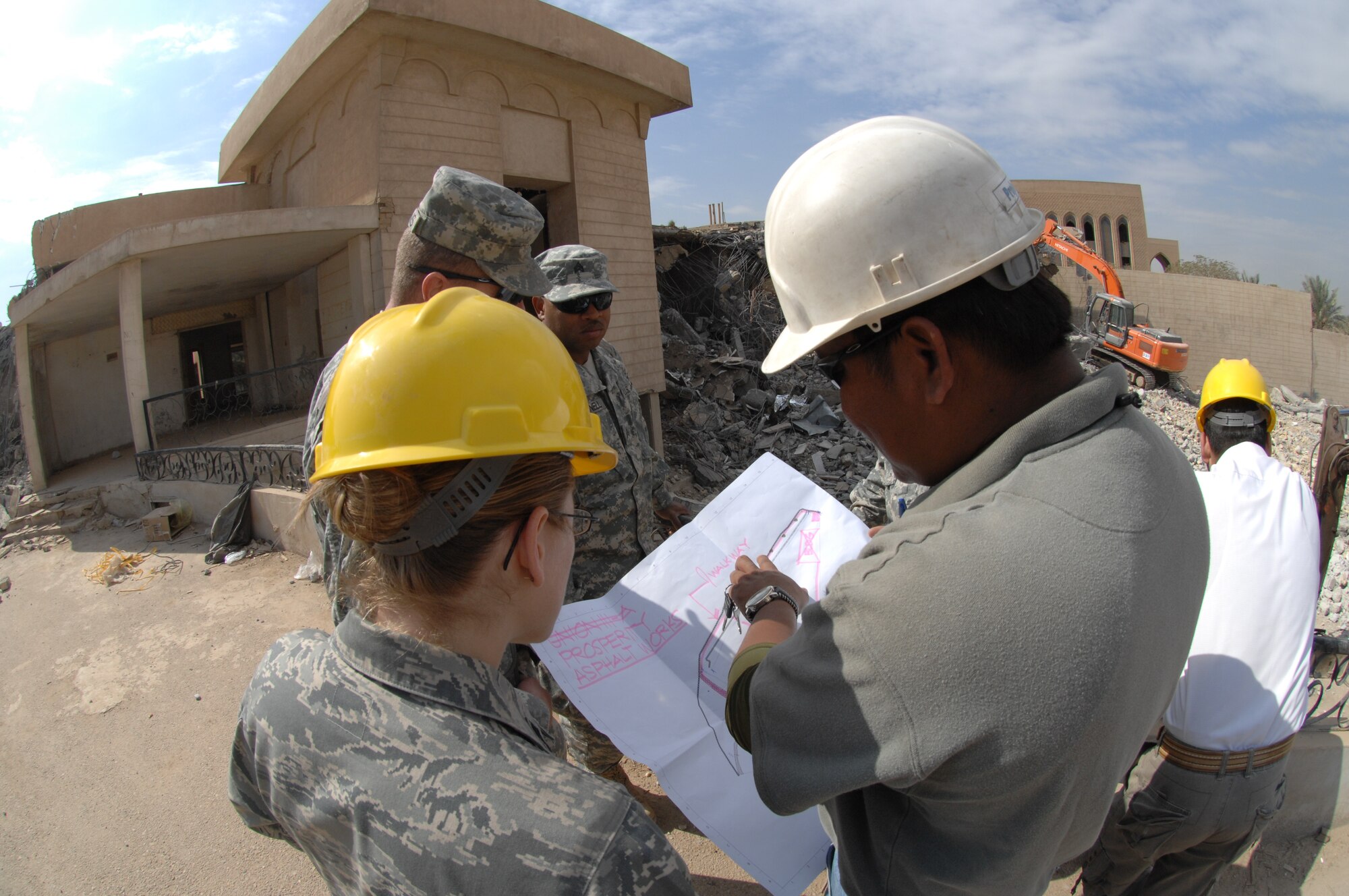 Capt. Michelle Sterling, Joint Area Support Group – Central project payment officer, goes over the demolition plans with her team members while one of the three villas once belonging to bath party members is being demolished. The villas are now being demolished to make room for a new foreign embassy. (U.S. Air Force photo by Staff Sgt. Tim Beckham)