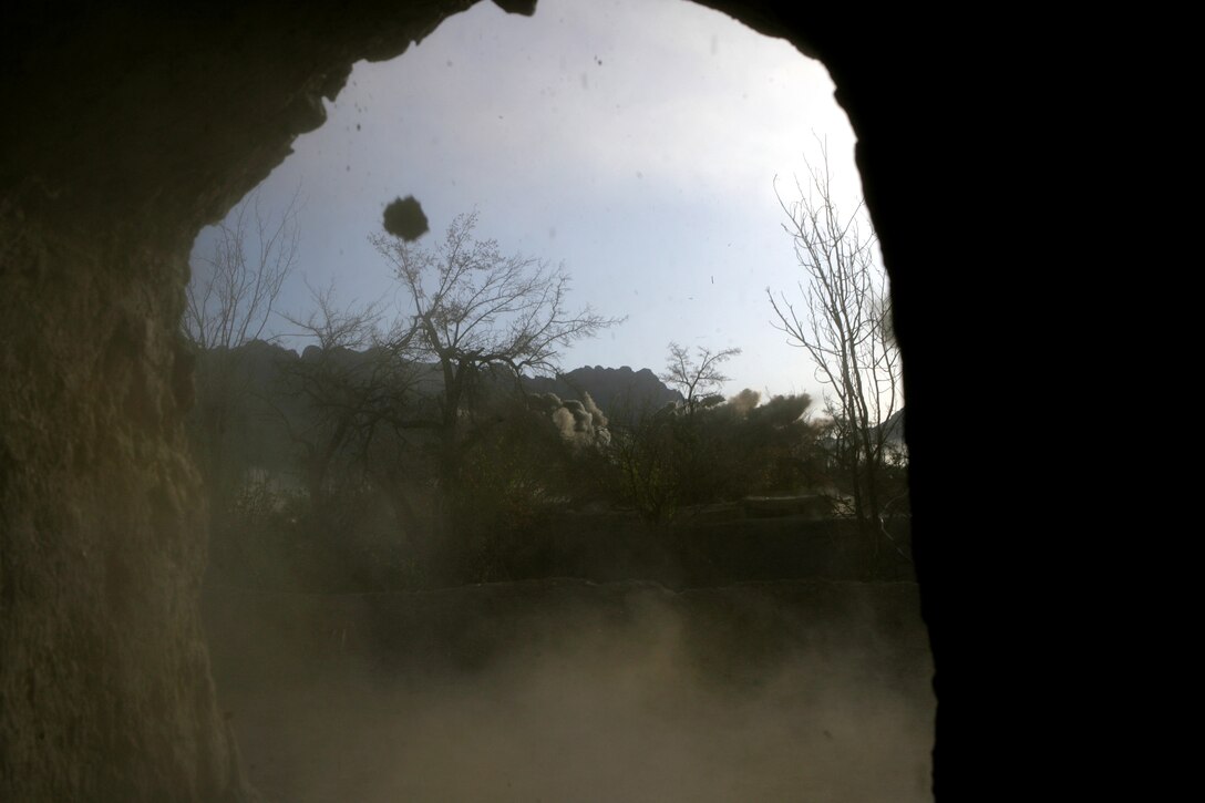 Dirt and debris from an explosion fly through a window as U.S. Marines conduct an operation in the abandoned village of Now Zad in Helmand province, Afghanistan, April 3, 2009.