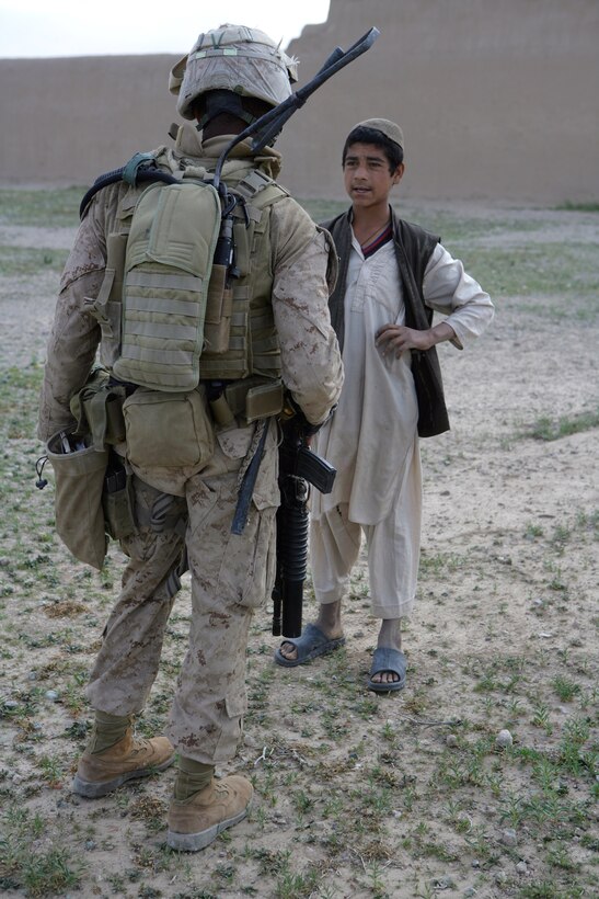 U.S. Marine Cpl. Raymond Robinson talks to a young boy April 4, 2009, during a local security patrol in the abandoned village of Now Zad in Helmand Province of Afghanistan, April 4, 2009. 