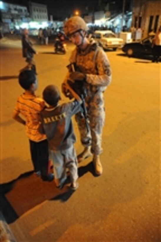 U.S. Army 1st Lt. Joshua Trulock from the 978th Military Police Company, 93rd Battalion, 8th Military Police Brigade talks to children during a joint patrol with Iraqi police officers in the Kadamiyah area of Baghdad, Iraq, on March 27, 2009.  