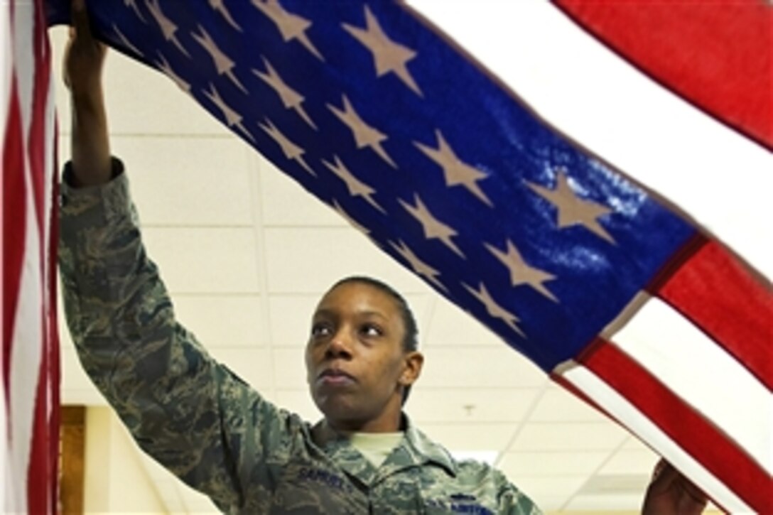 U.S. Air Firce Staff Sgt. Star Samuels hangs up a U.S. flag used to accompany remains of fallen warriors during the dignified transfer operation at the Charles C. Carson Center for Mortuary Affairs on Dover Air Force Base, Del., March 31. Samuels is deployed from the 43rd Force Support Squadron, Pope Air Force Base, N.C.