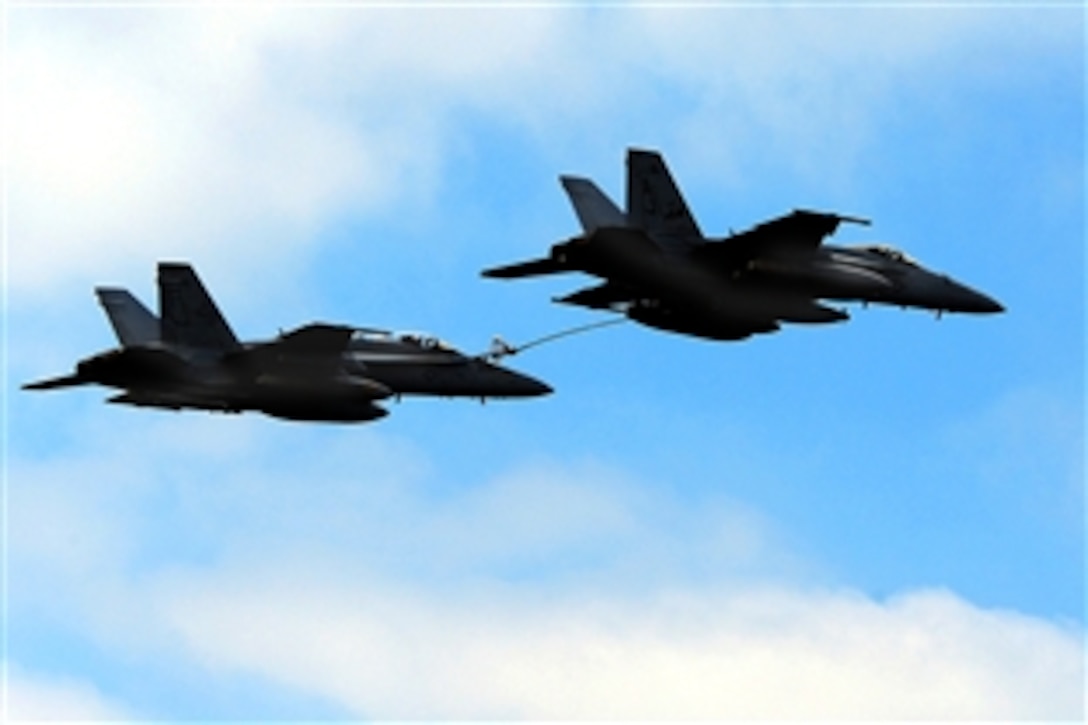 An F/A-18E Super Hornet, right, re-fuels an F/A-18 Hornet during an air power demonstration over the aircraft carrier USS Theodore Roosevelt in the Mediterranean Sea April 2, 2009.