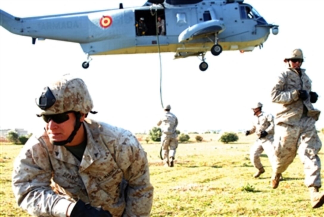 U.S. Marine Corps Lance Cpl. Greg Deane (left) from the Fleet Anti-Terrorism Support Team Europe takes position after fast roping from a Spanish navy SH-3 Sea King helicopter in preparation for exercise Phoenix Express 2009 on April 2, 2009.  Phoenix Express is a semi-annual exercise that includes European and African nations and helps to increase interoperability by developing individual and collective maritime proficiencies of participating nations, as well as promoting friendship, mutual understanding and cooperation.  