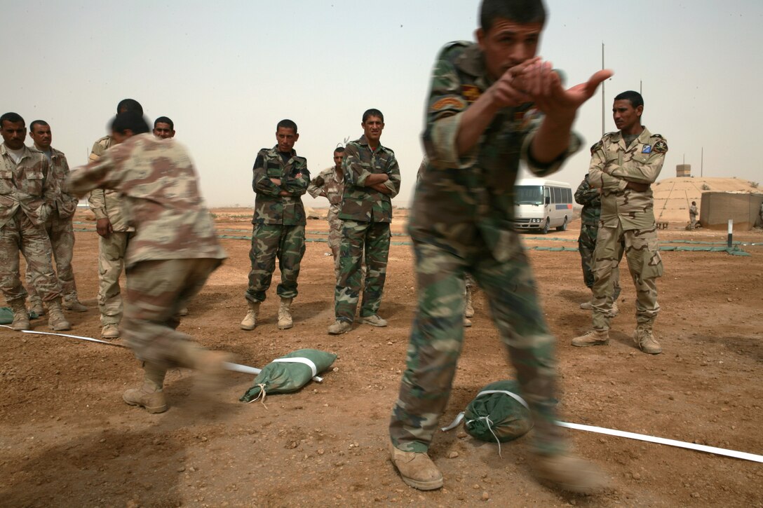Iraqi commandos with the 7th Iraqi Army Division practice two-man room entering while other commandos watch, April 7, 2009 at Al Asad Air Base, Iraq. Reconnaissance Marines with 2nd Platoon, Bravo Company, 1st Reconnaissance Battalion, Regimental Combat Team 8, have been training Iraqi commandos with the 7th Iraqi Army Division on fundamental infantry tactics during a month-long training evolution.
