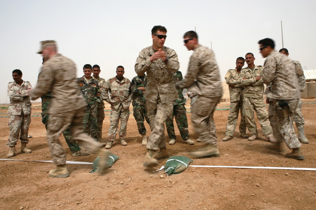 Reconnaissance Marines with 2nd Platoon, Bravo Company, 1st Reconnaissance Battalion, Regimental Combat Team 8, show Iraqi commandos with the 7th Iraqi Army Division how to properly enter a room with a four-man team, April 7, 2009 at Al Asad Air Base, Iraq. Marines with 1st Recon have been training Iraqi commandos with the 7th Iraqi Army Division on fundamental infantry tactics during a month-long training evolution.