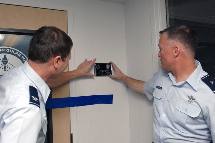 Col. Ross Victor (left), Coalition and Irregular Warfare Center of Excellence (CIWC) director and Brig. Gen. Kevin McLaughlin, United States Air Force Warfare Center vice commander, place a dedication placard near the CIWC entrance during the official ribbon cutting ceremony at Nellis Air Force Base, Nev., April 6.
(U.S. Air Force photo by Senior Airman Larry E. Reid Jr.)