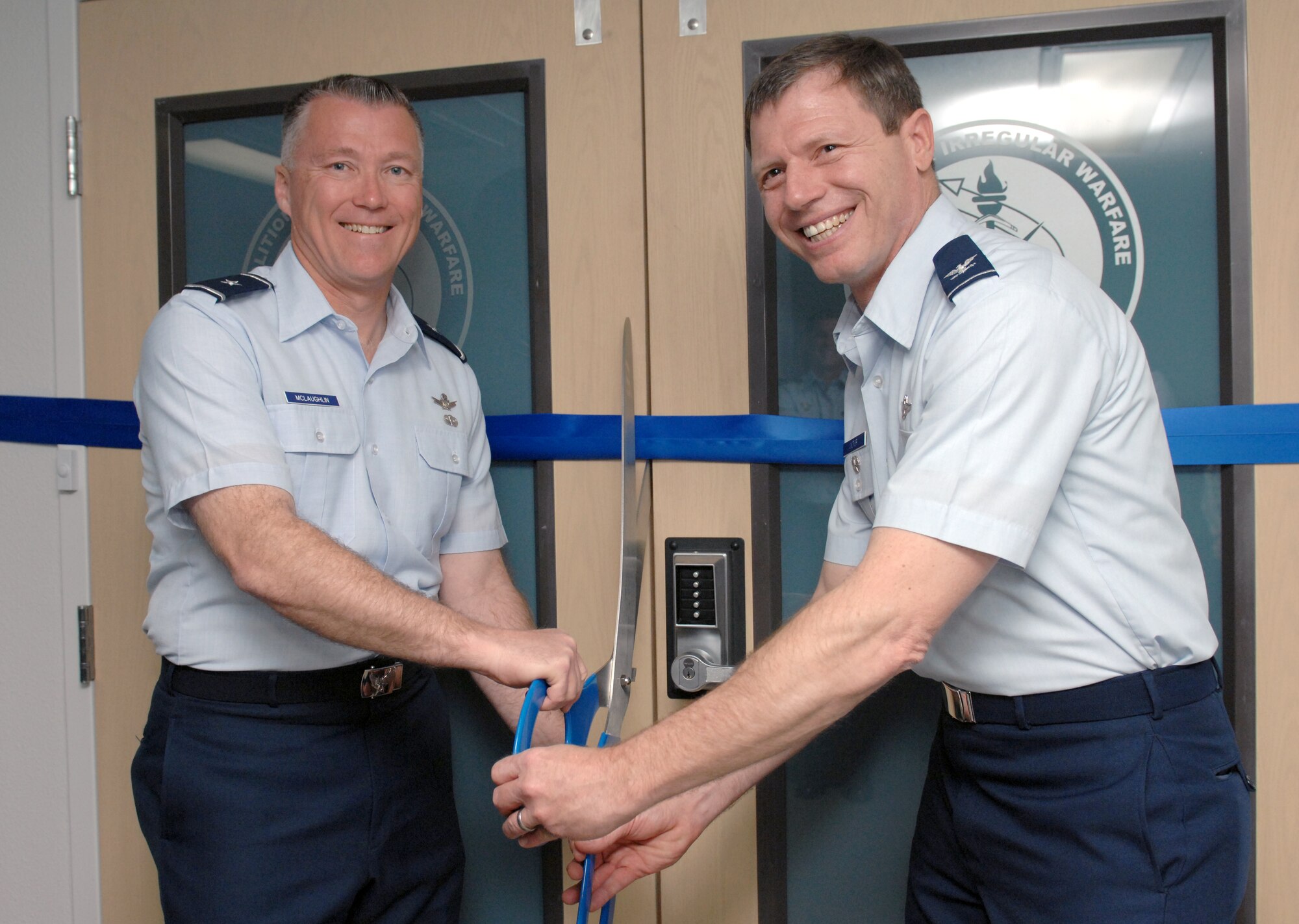 Brig. Gen. Kevin McLaughlin, United States Air Force Warfare Center (USAFWC) vice commander and Col. Ross Victor, Coalition and Irregular Warfare Center of Excellence (CIWC) director, cut the ribbon for the opening of the CIWC facility at Nellis Air Force Base, Nev., Apr 6. Operating under the scope of the USAFWC, the CIWC’s mission is to evaluate, analyze and train Airmen and U.S. coalition partners on how to integrate irregular war fighting capabilities in to conventional warfare. The opening of this center is a first for the Air Force. (U.S. Air Force photo by Senior Airman Larry E. Reid Jr.)  (Released)

