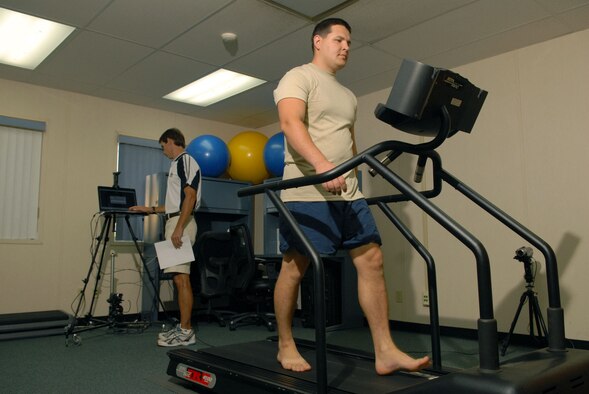 Staff Sgt. Angel Villalobos, 15th Operations Support Squadron aircrew flight equipment, walks barefoot on a treadmill at the Human Performance and Rehabilitation Center April 7 at Hickam Air Force Base, Hawaii. He came to the HPARC seeking treatment for shin splints, which have caused him pain and decreased his running time for several years. Bryan Hafler, an HPARC fitness specialist and Iron Man, analyzed Sergeant Villalobos's gait to see what the source of the problem may be. (U.S. Air Force photo/Senior Airman Carolyn Viss) 