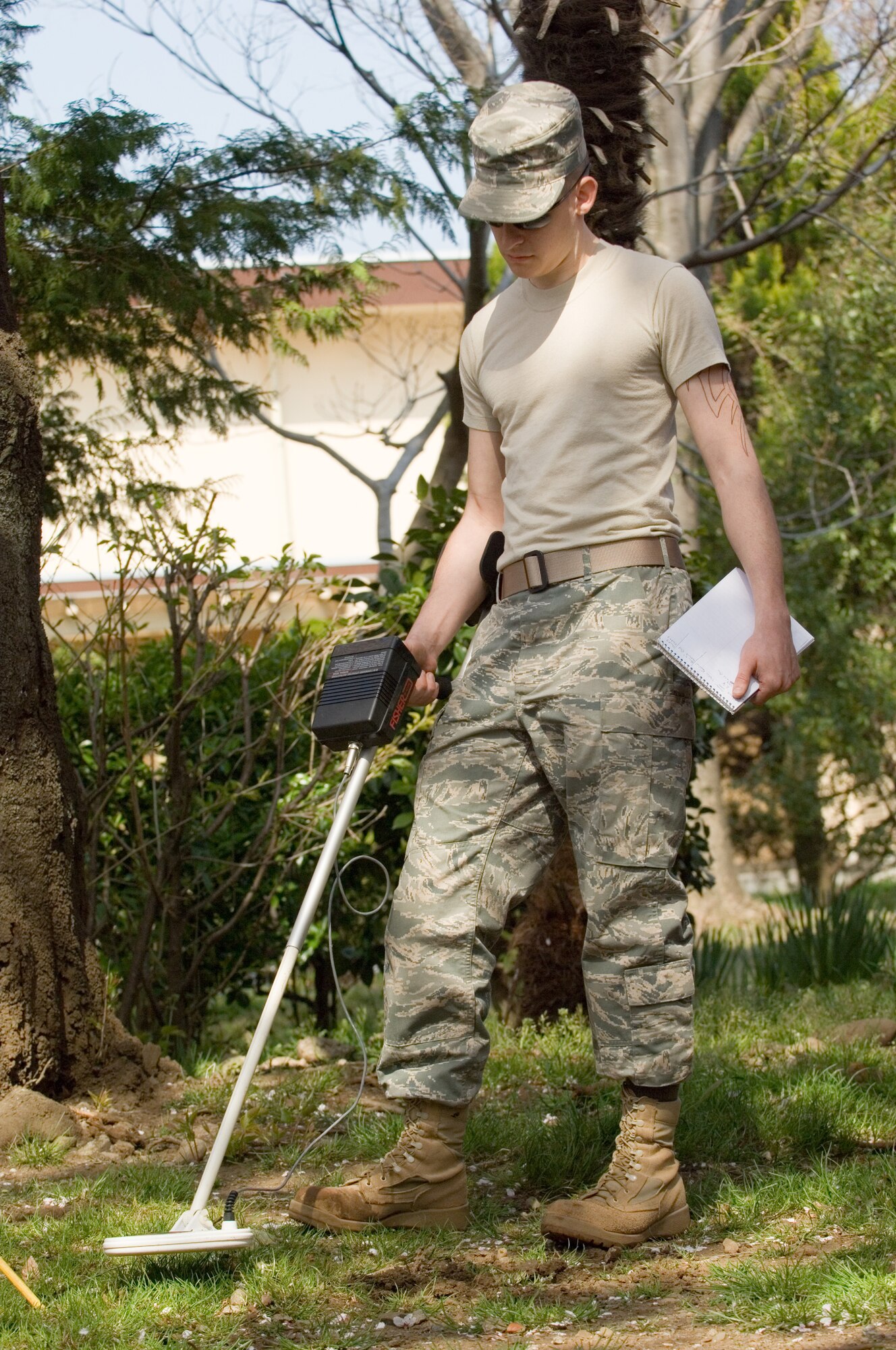 YOKOTA AIR BASE, Japan -- Airman 1st Class Jordan Ward, 374th Civil Engineer Squadron utilities system journeyman, searches for the location of a water valve under cherry blossom trees April 7. (U.S. Air Force photo/Osakabe Yasuo)